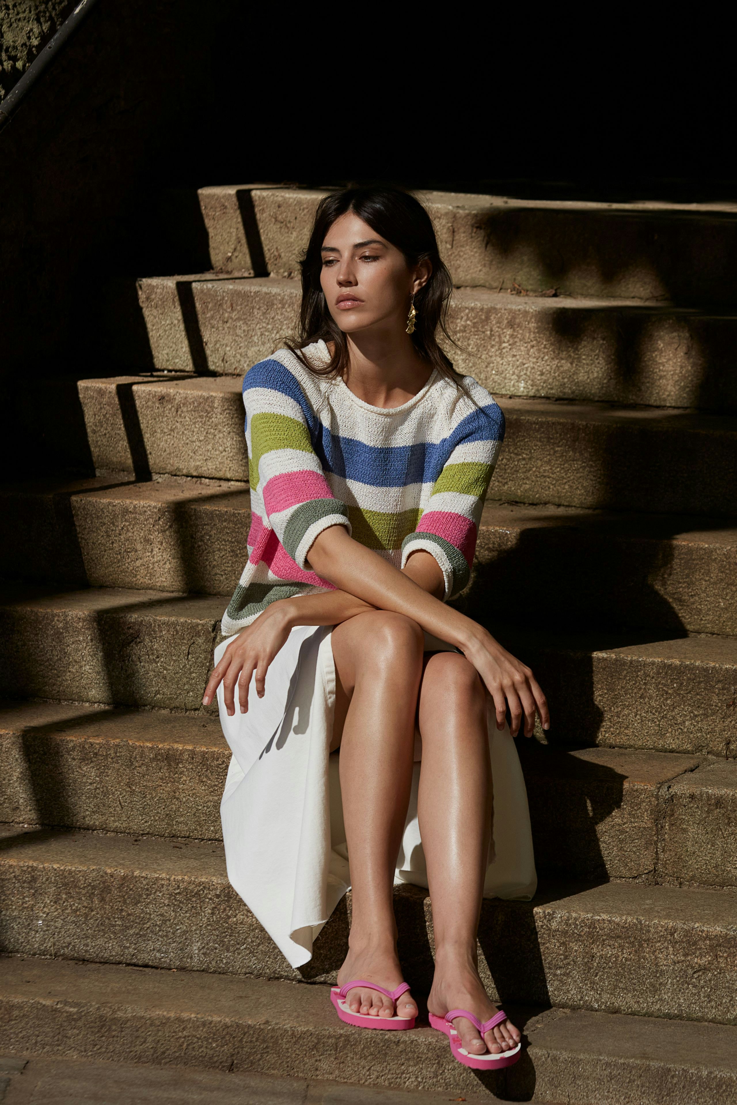 Eleganter Wickelrock: Frau in einem weißen Wickelrock kombiniert mit einem bunten gestreiften Pullover.