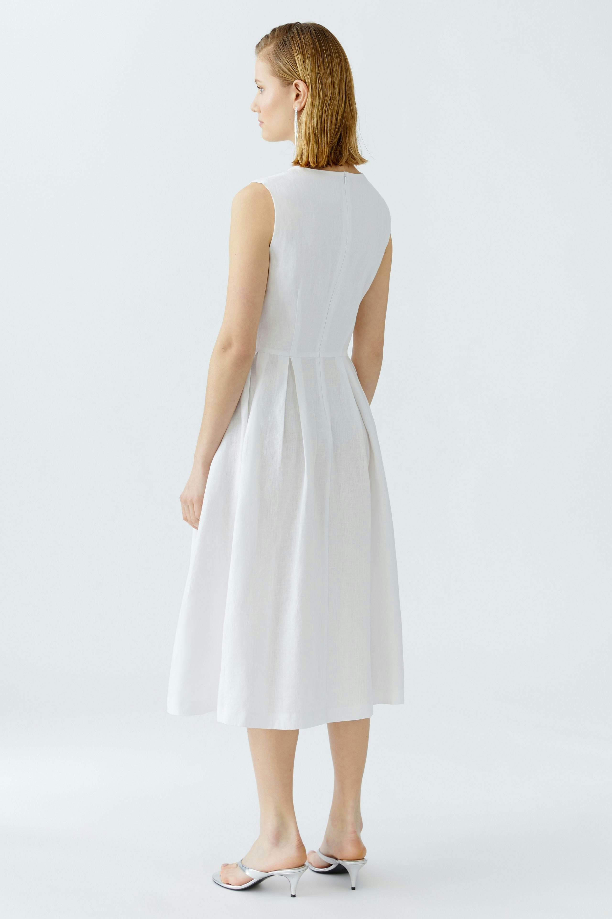 Casual white midi dress: Woman in a sleeveless design with a flowing silhouette.
