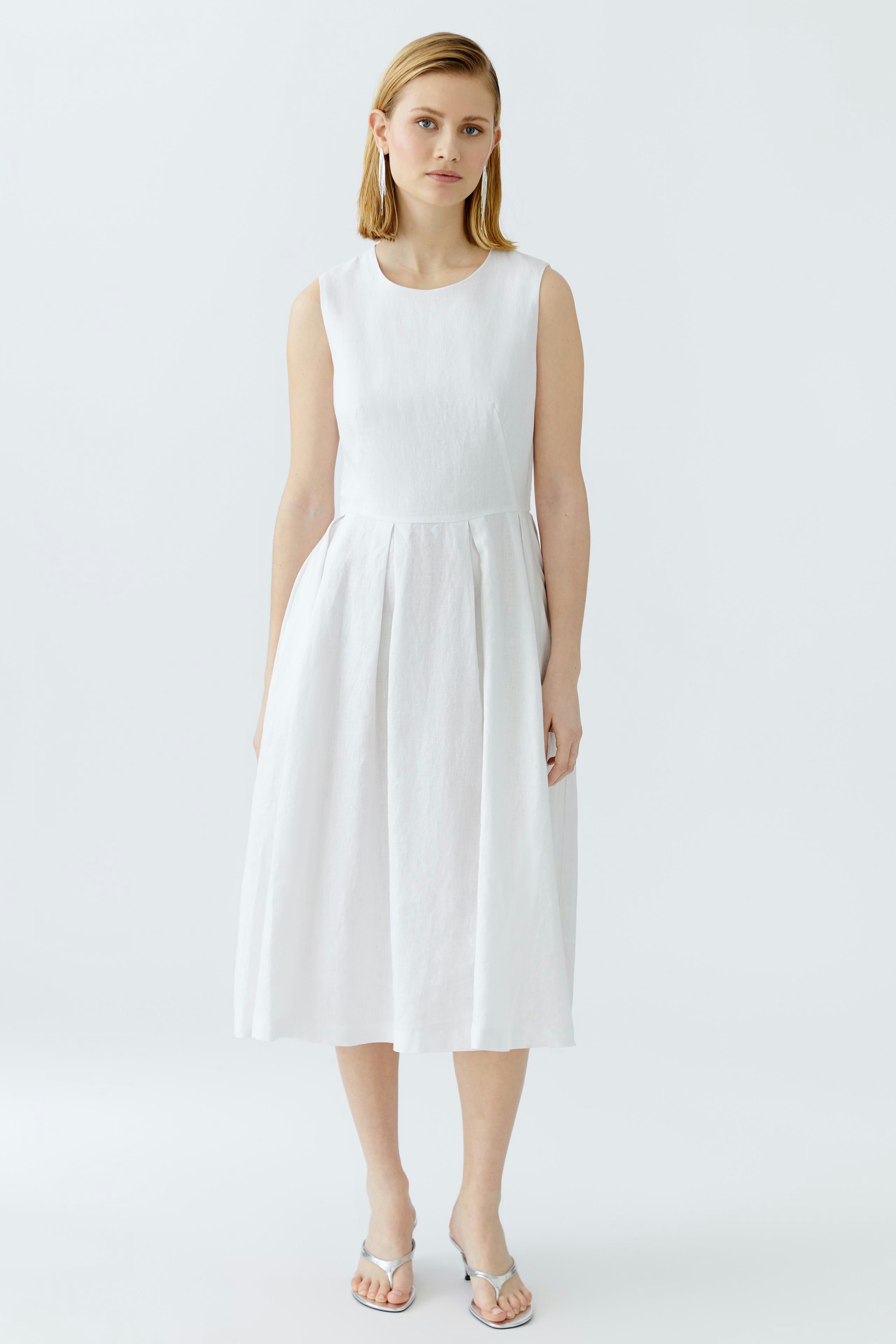 Casual white midi dress: Woman in a sleeveless dress with a flowing skirt, perfect for warm days.