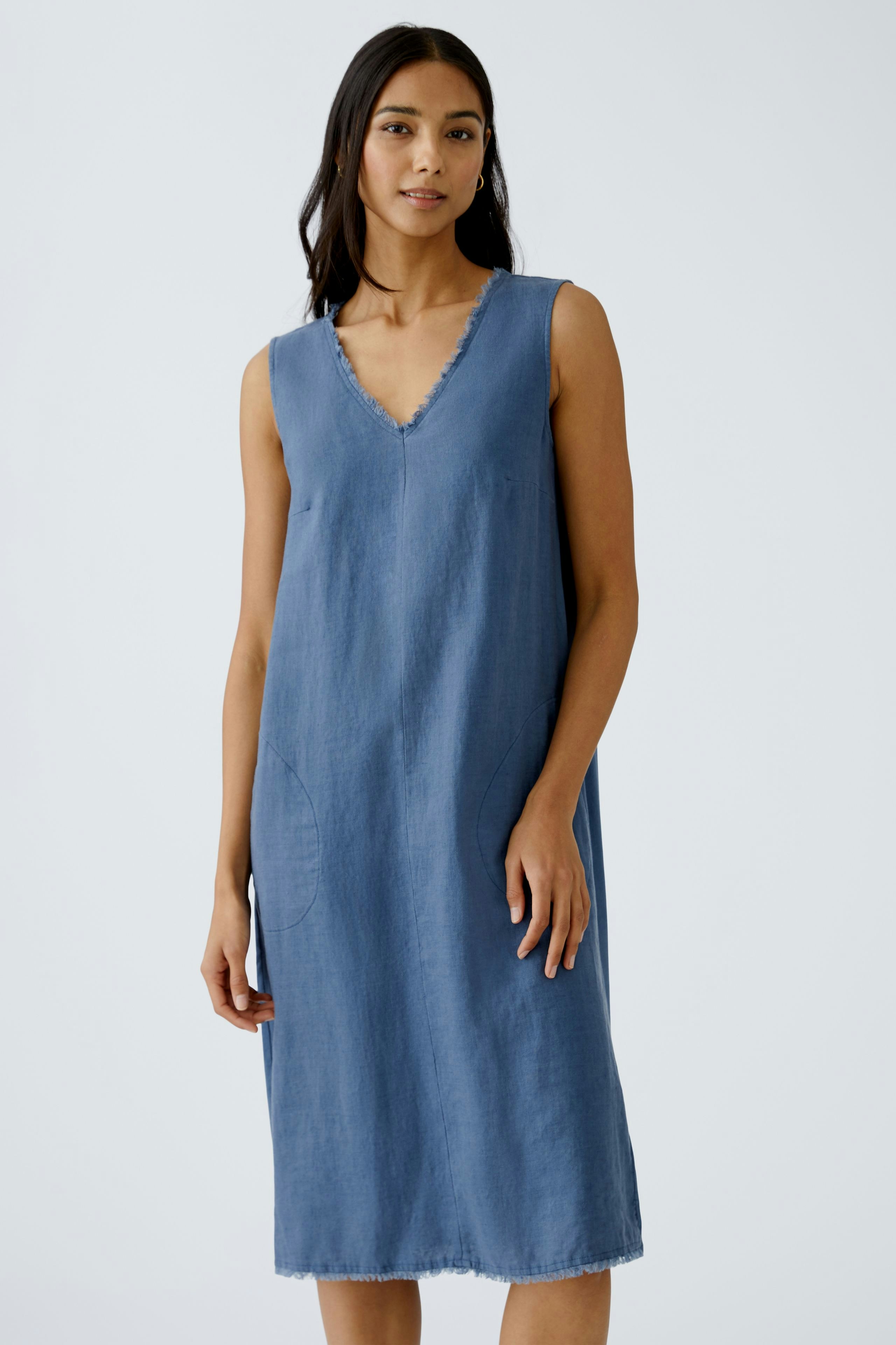 Casual A-line dress: A woman in a sleeveless blue dress with a V-neck and side pockets.