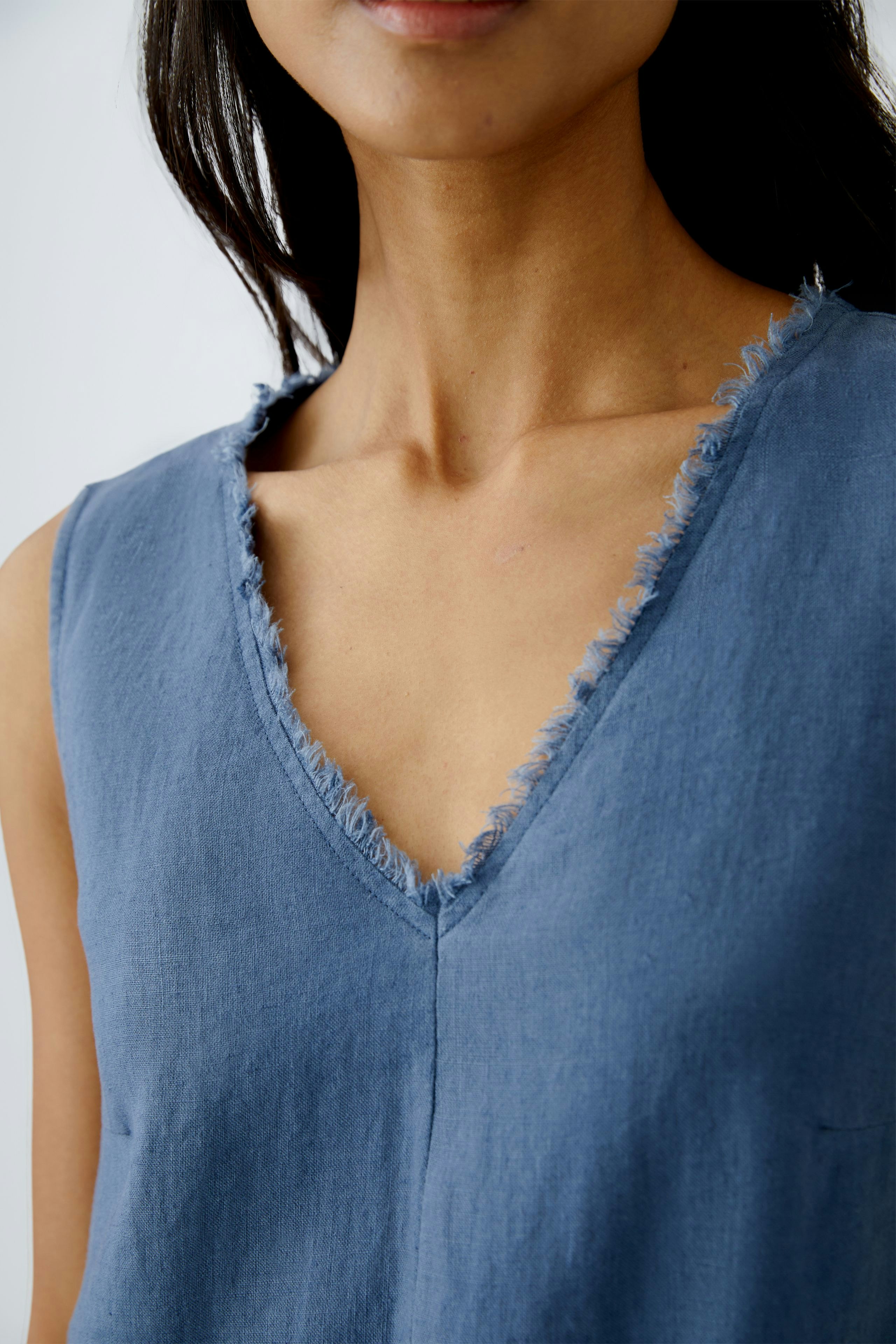 A-line dress: Woman in a blue sleeveless dress with a frayed neckline, exuding effortless style.