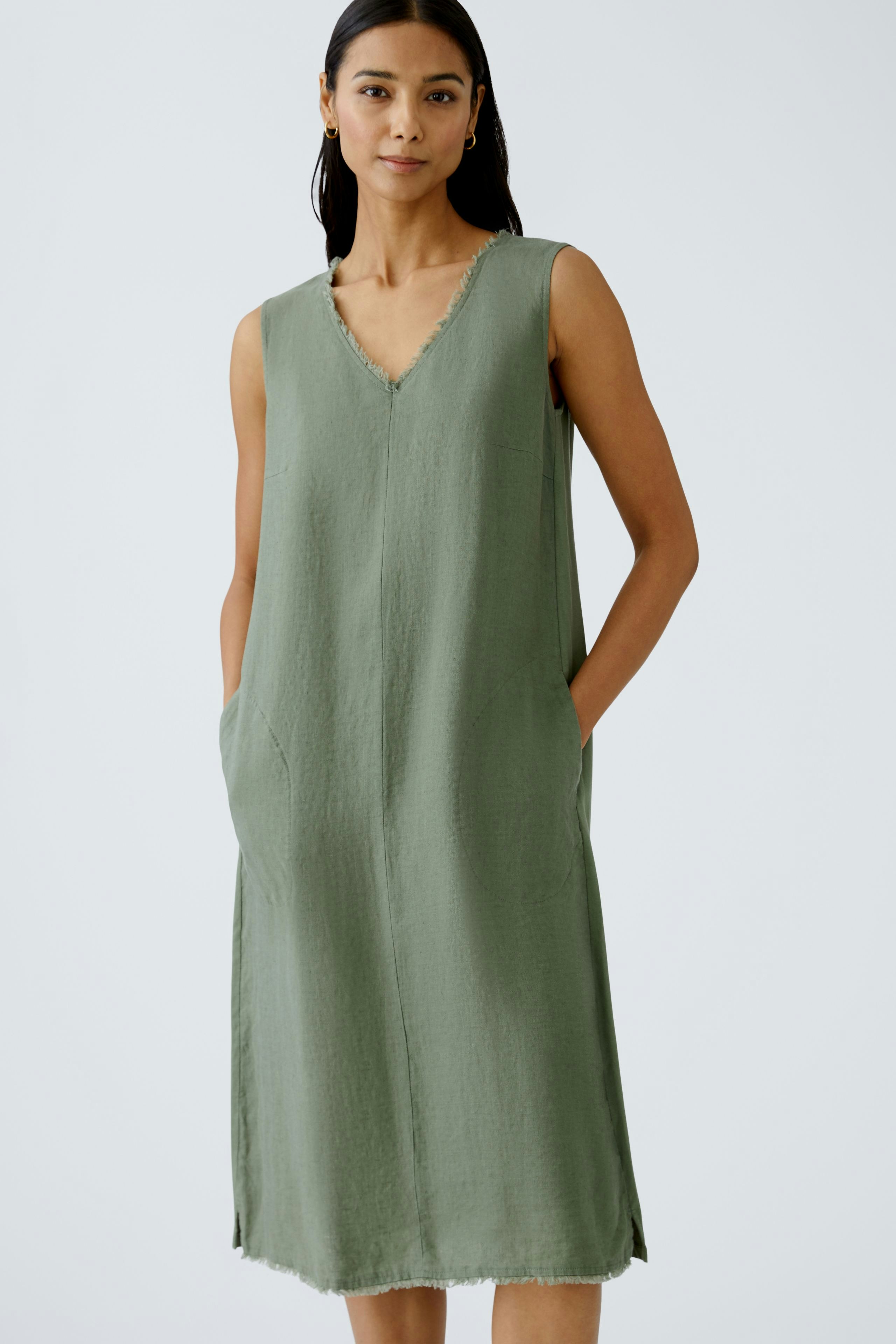 Casual A-line dress: A woman in a green sleeveless dress with pockets, perfect for warm days.