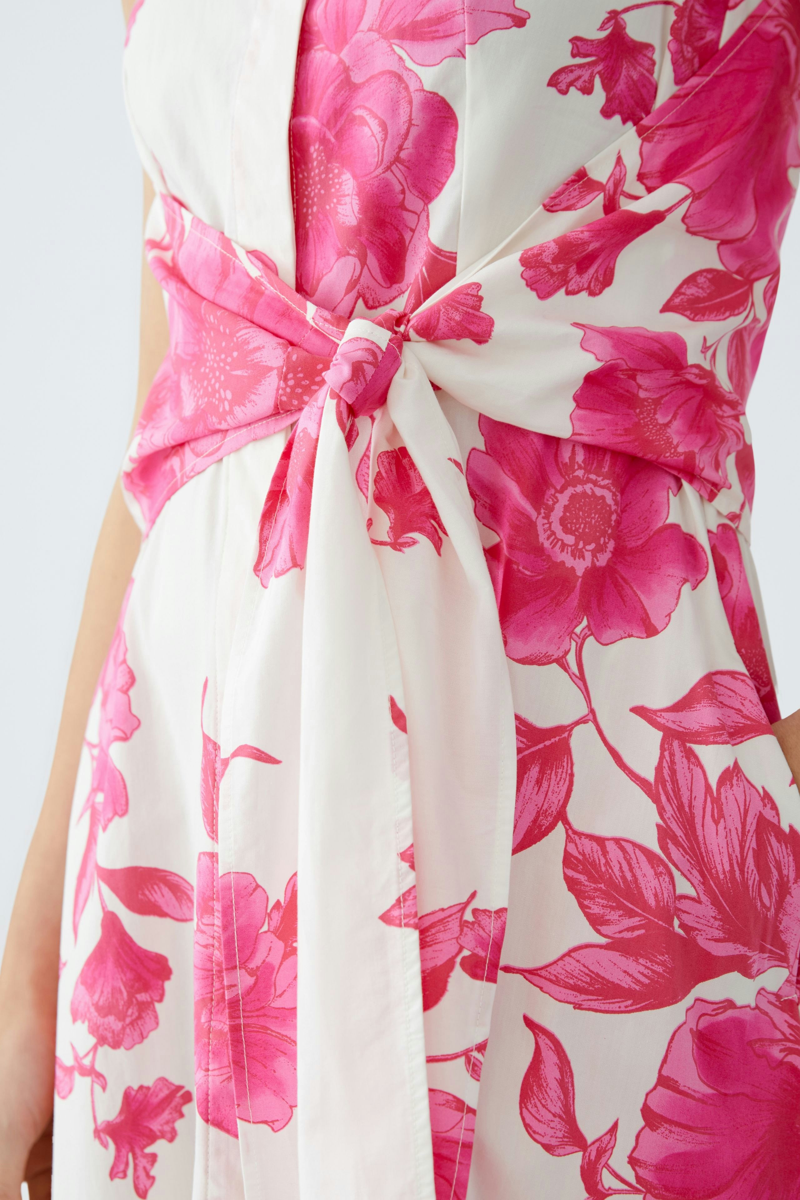 Elegant maxi dress: A woman showcases a floral design with a tied waist, perfect for summer occasions.
