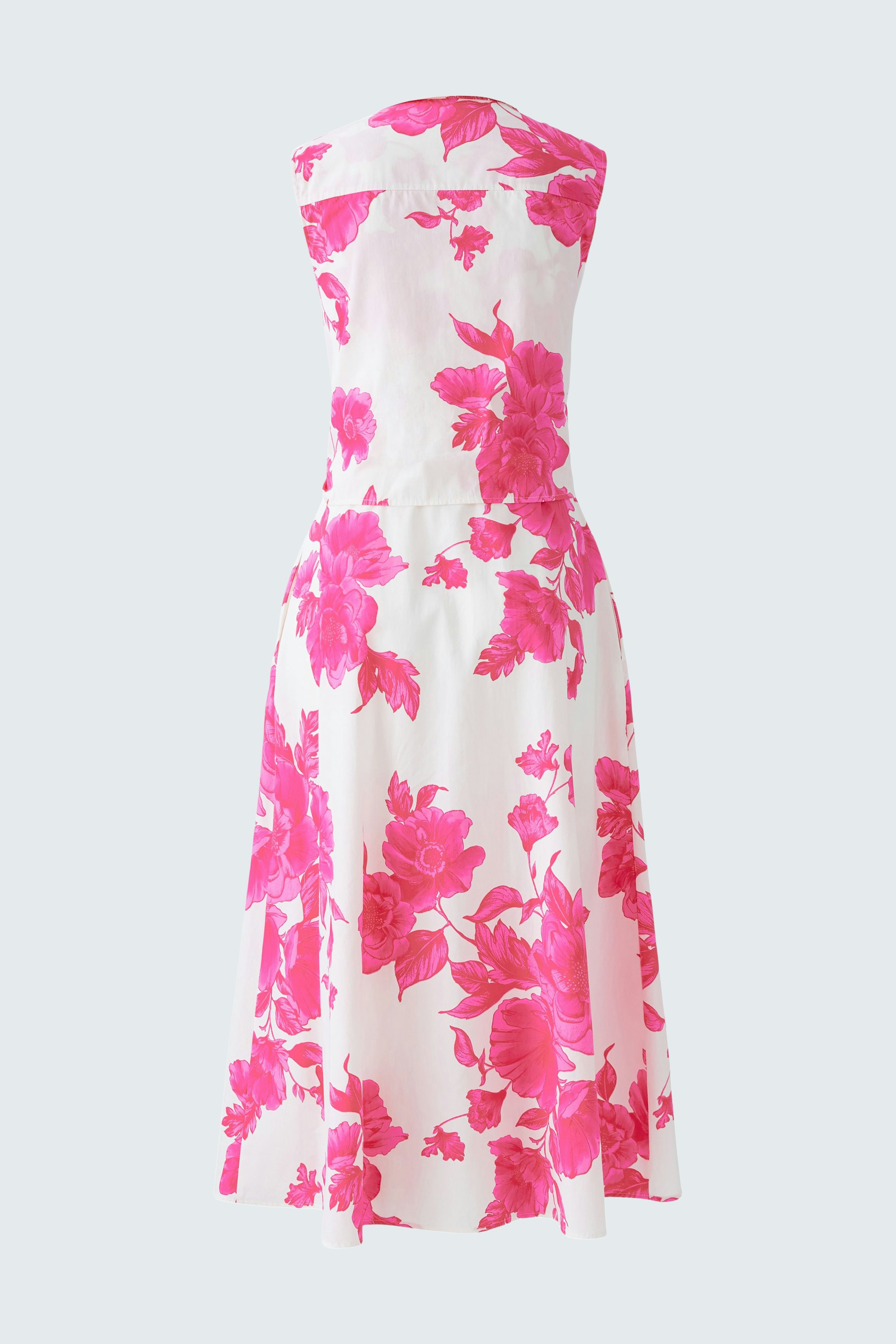 Elegant maxi dress: A woman in a vibrant pink floral maxi dress, showcasing a stylish summer look.