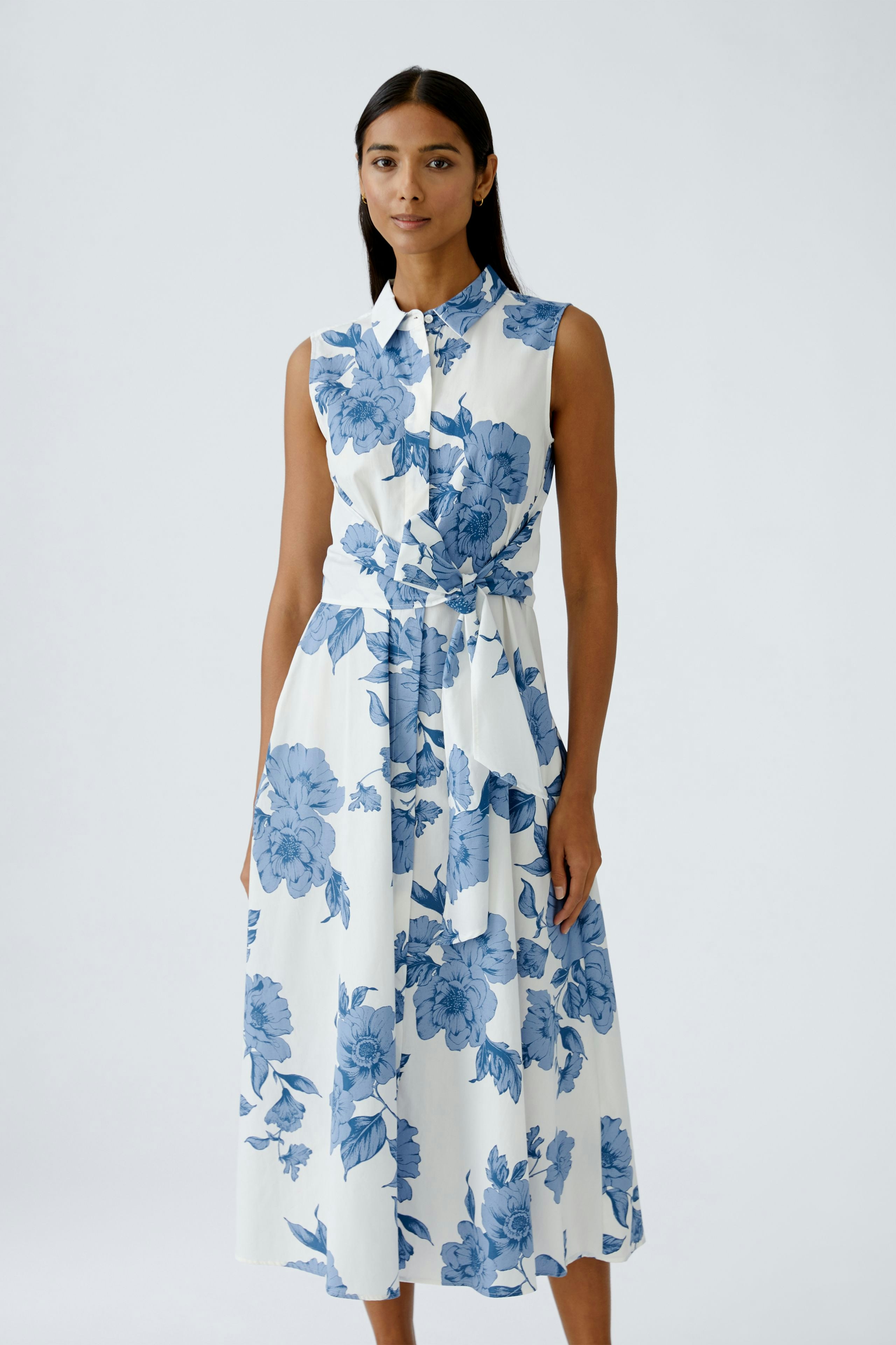 Casual maxi dress: Woman in a floral print dress with a collar, featuring a fitted waist and flowing skirt.