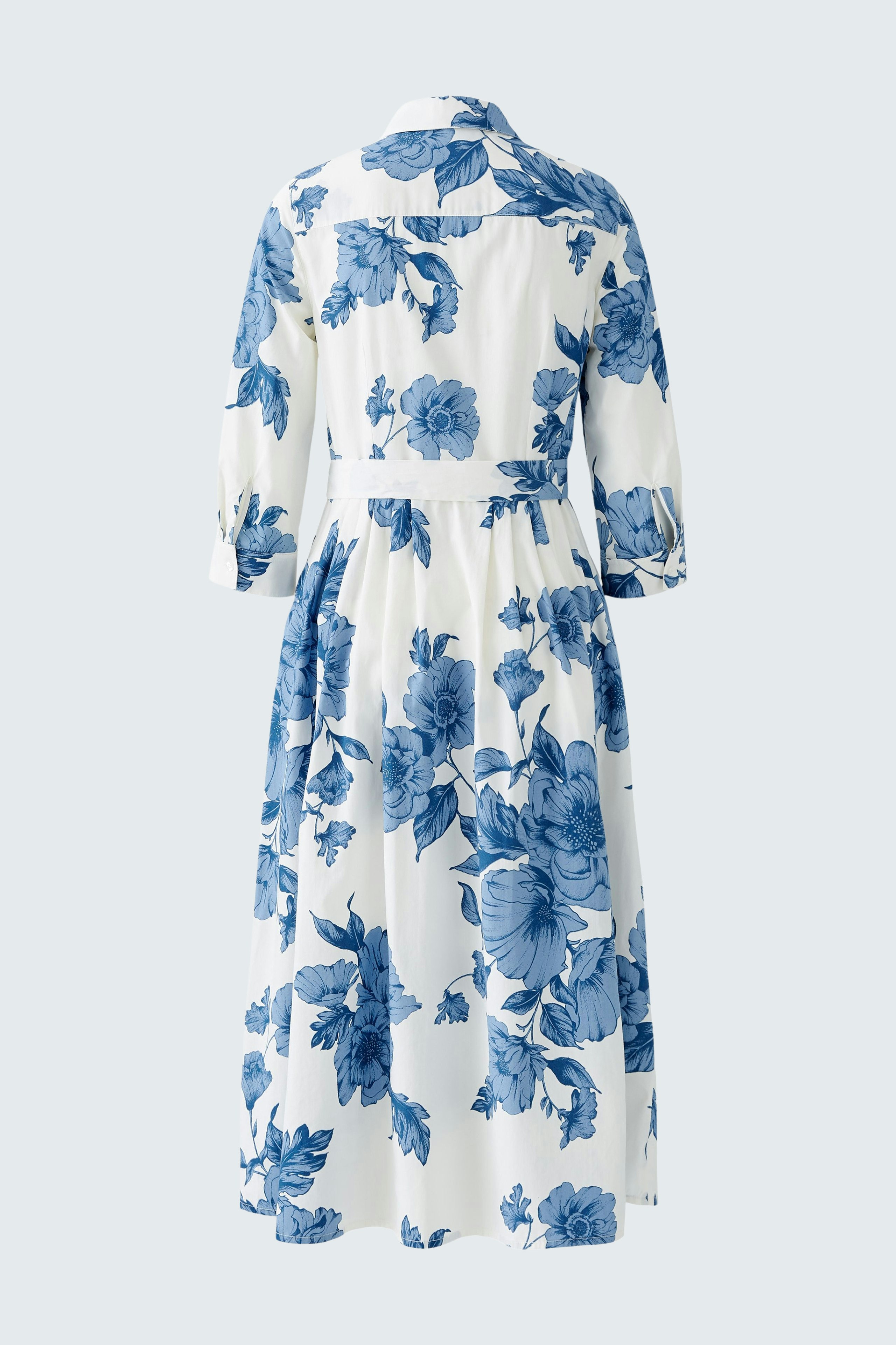 Elegant midi dress: A woman in a floral-patterned dress with a cinched waist and three-quarter sleeves.