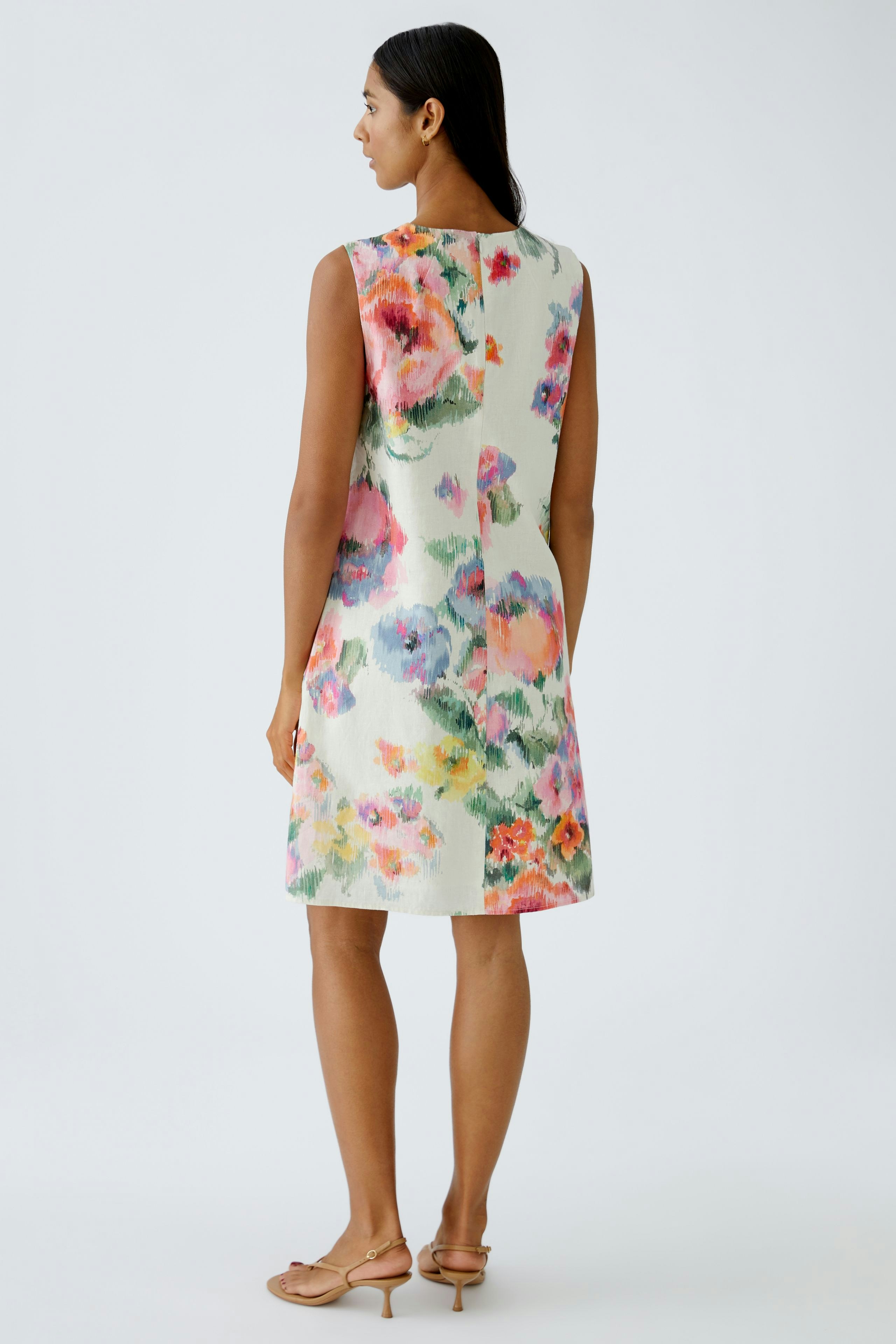 Floral A-line dress: Woman in a colorful floral A-line dress, showcasing a vibrant summer style.