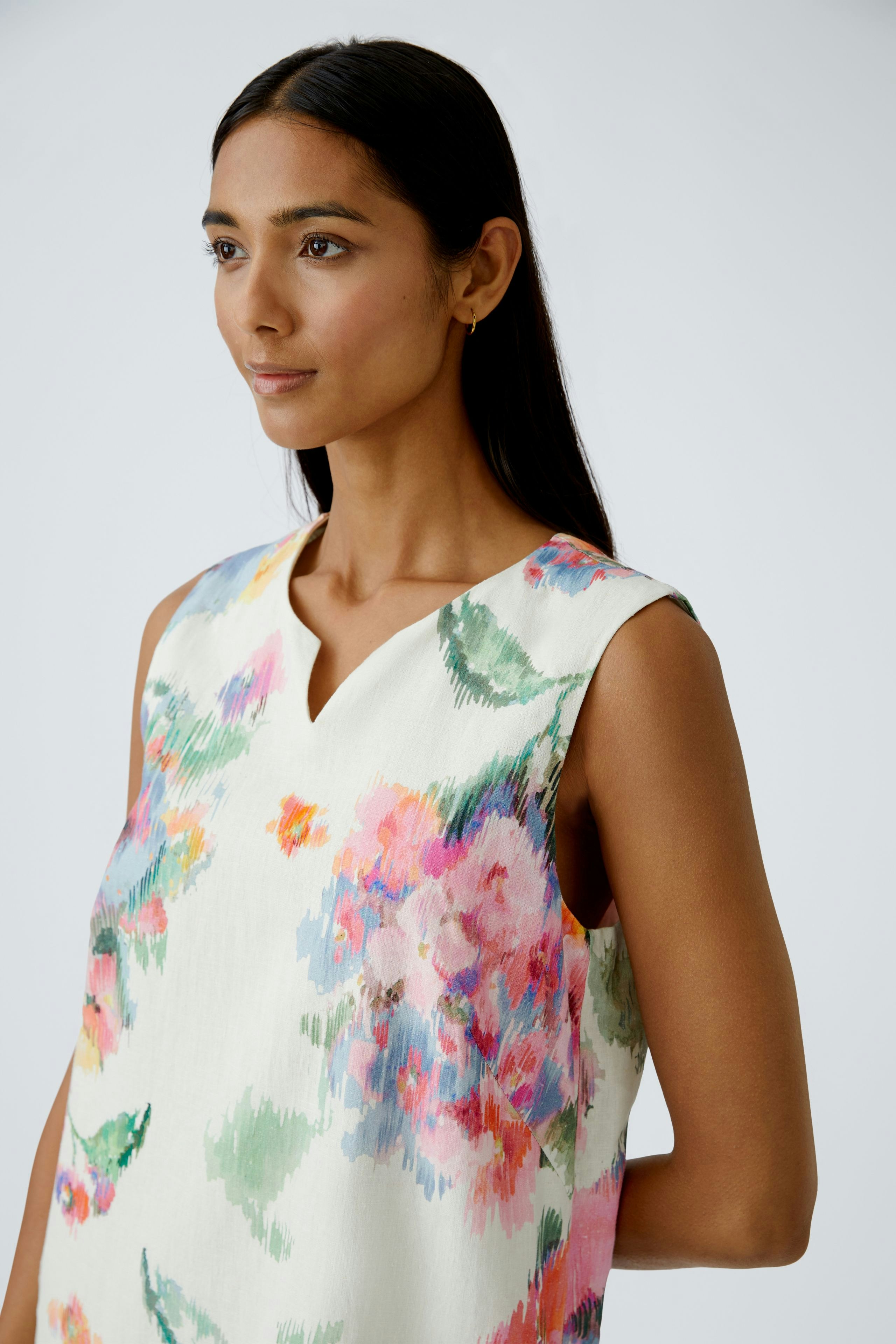 Floral A-line dress: Woman in a sleeveless dress with vibrant flowers, perfect for summer outings.
