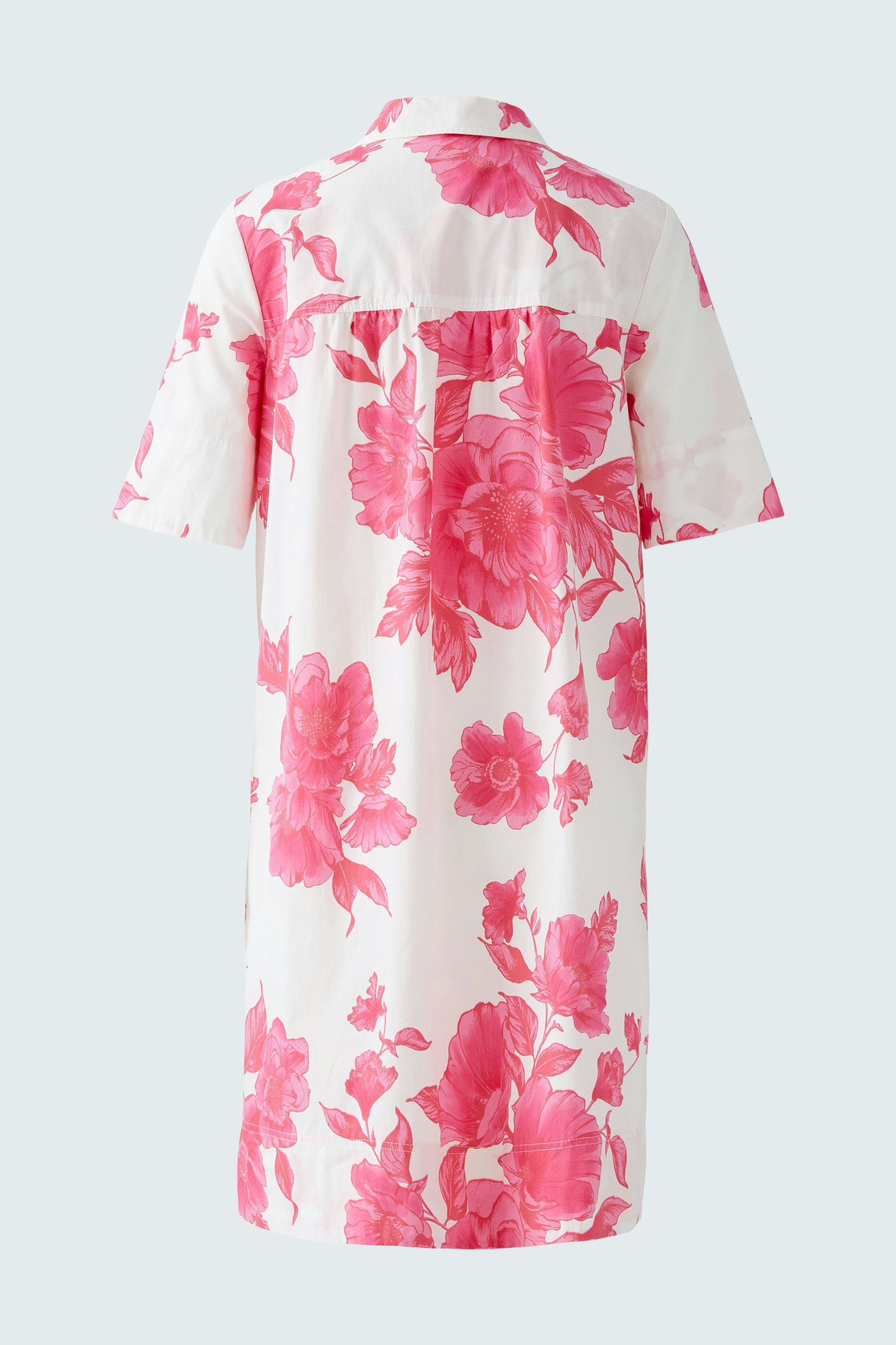A-line dress: A woman in a floral pink dress with short sleeves and a collar, showcasing a relaxed style.