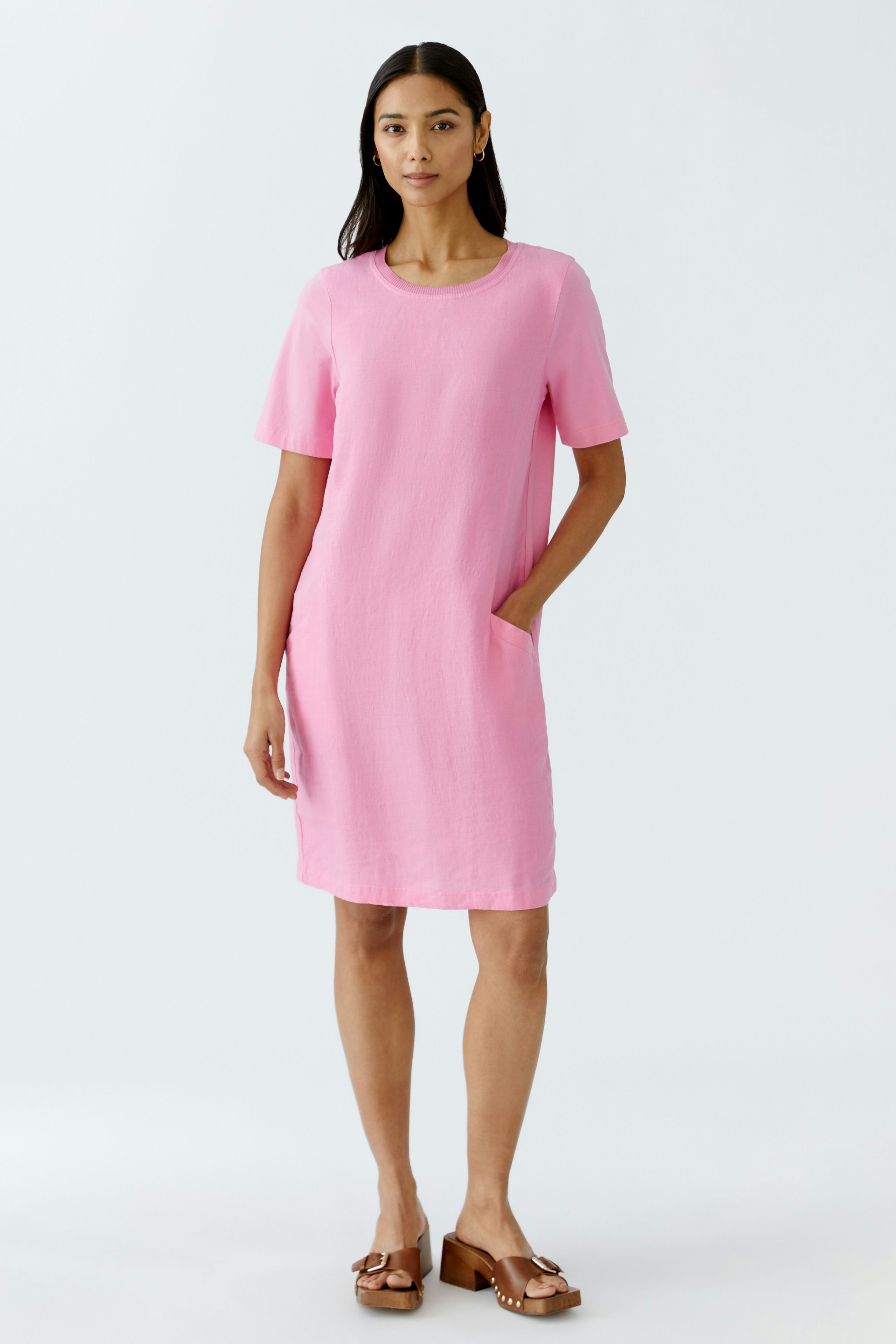Casual women's dress: A woman in a pink short-sleeve dress with pockets, exuding effortless style.