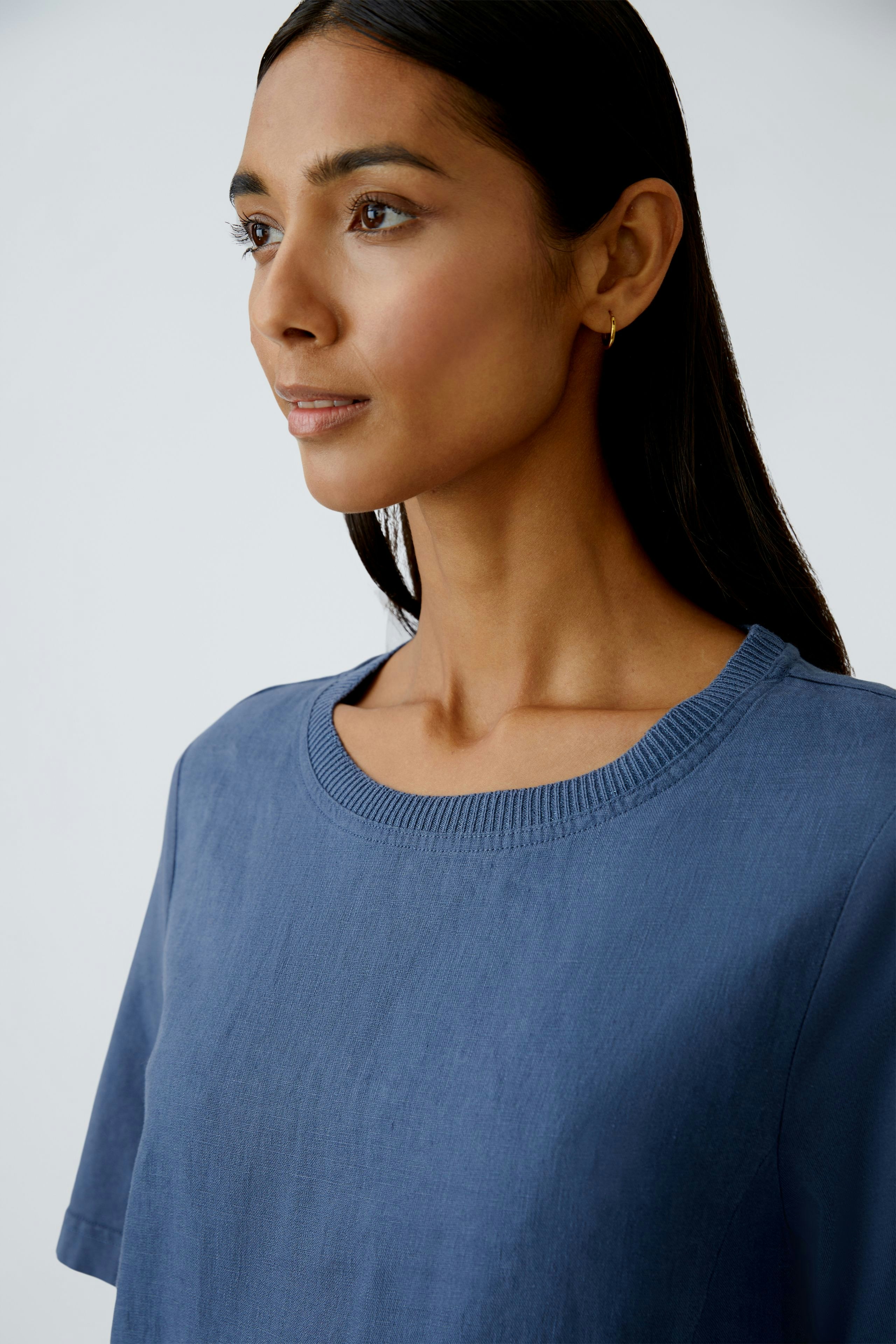 Casual women's dress: A woman in a blue dress with a relaxed fit and short sleeves.