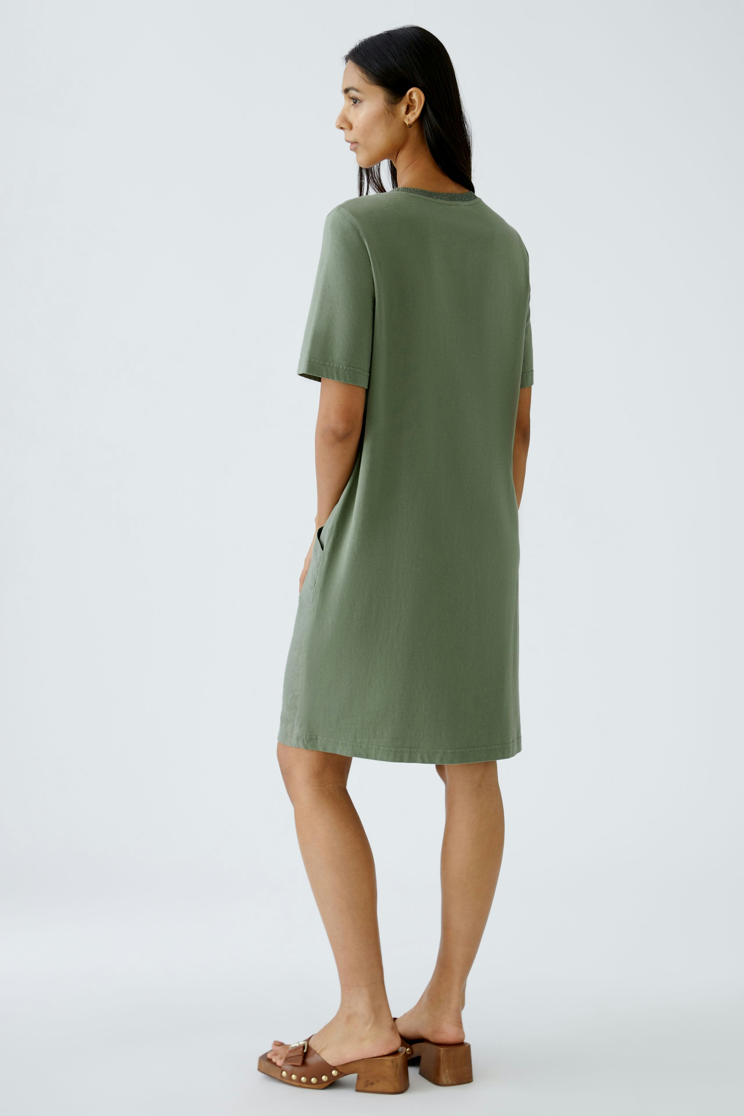 Casual women's dress: A woman in a relaxed green dress with short sleeves, perfect for warm days.