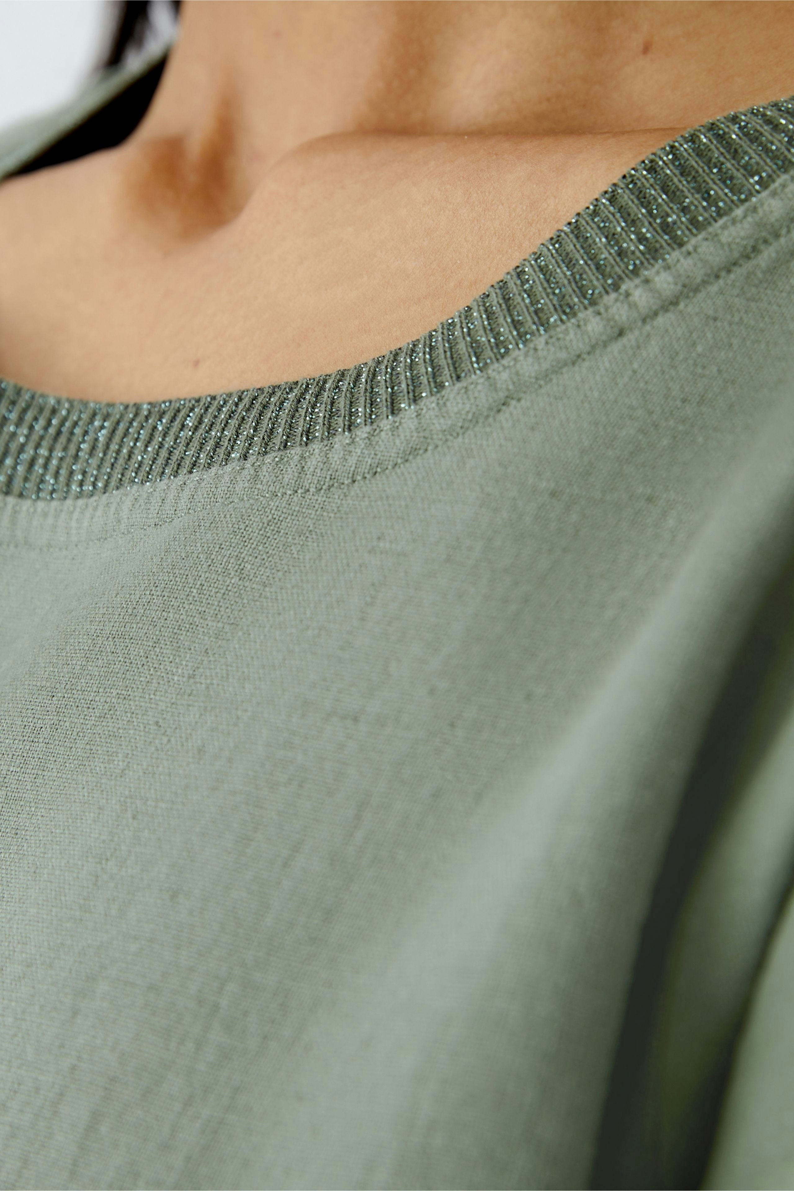 Elegant women's dress with a subtle green hue and a stylish neckline detail.