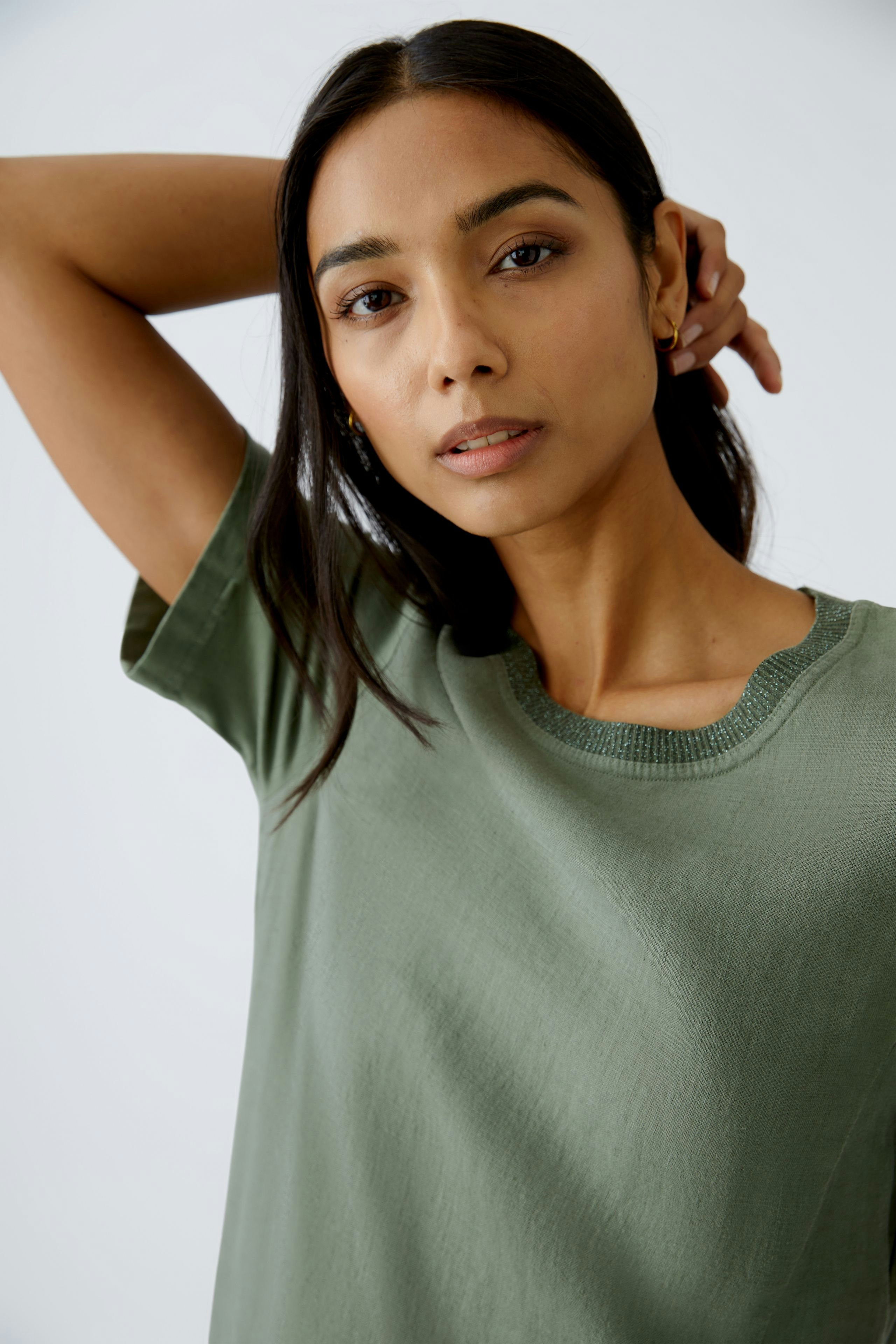 Casual women's dress: A woman in a relaxed green dress with short sleeves poses confidently.