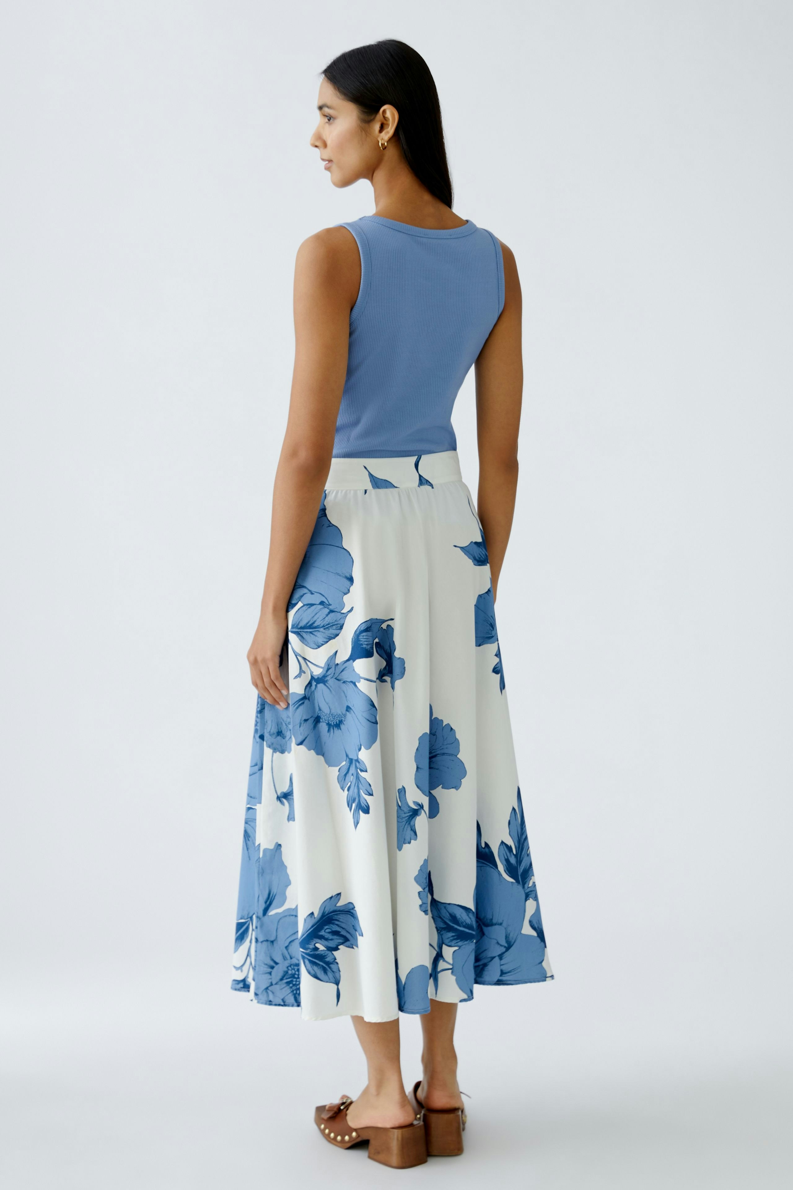 Elegant A-line skirt: Woman in a floral skirt with blue and white patterns, showcasing a flowing design.