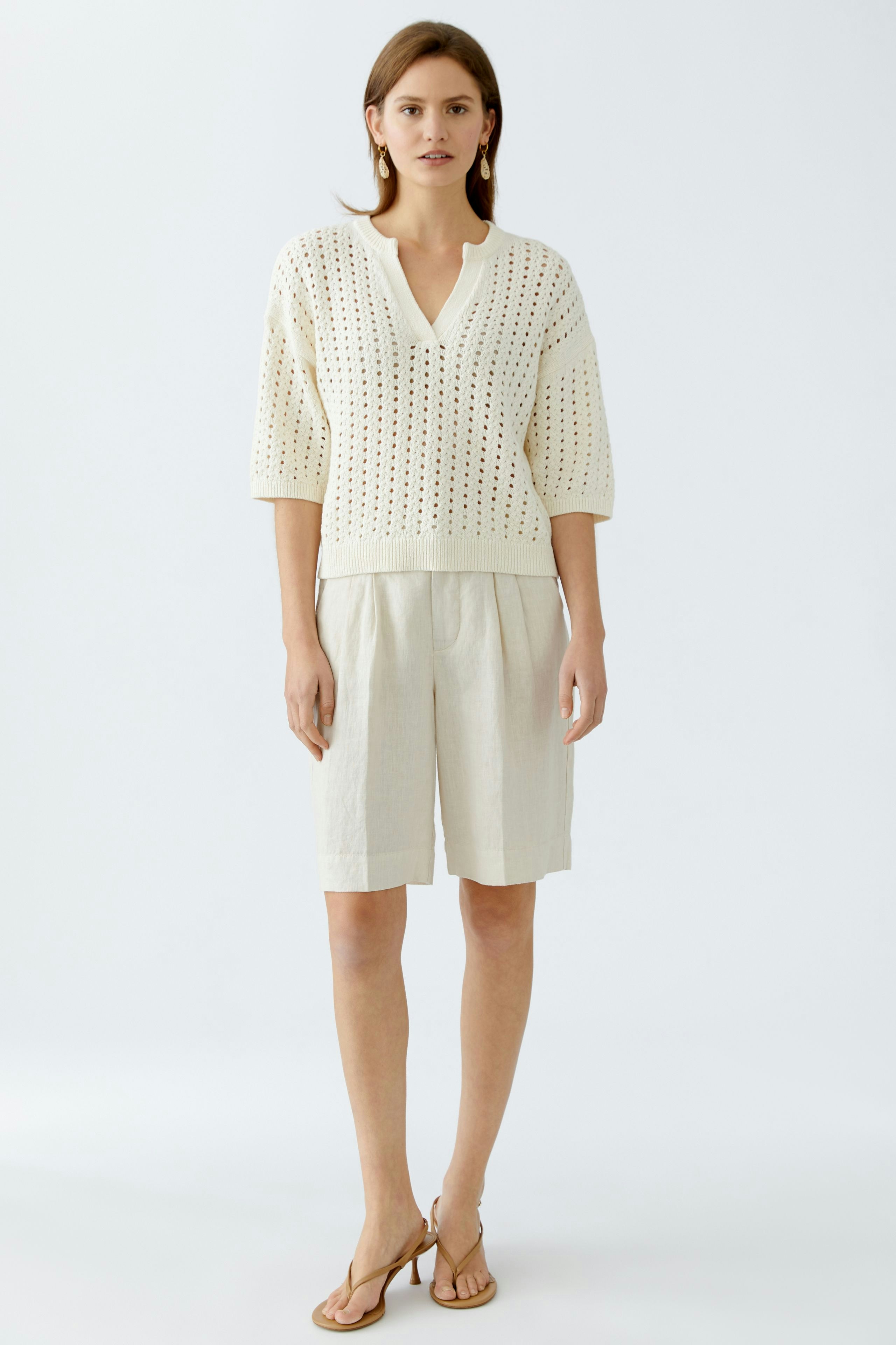 Helle Damen-Bermuda: Frau in beiger, luftiger Bermuda mit lockerer Passform und seitlichen Taschen.