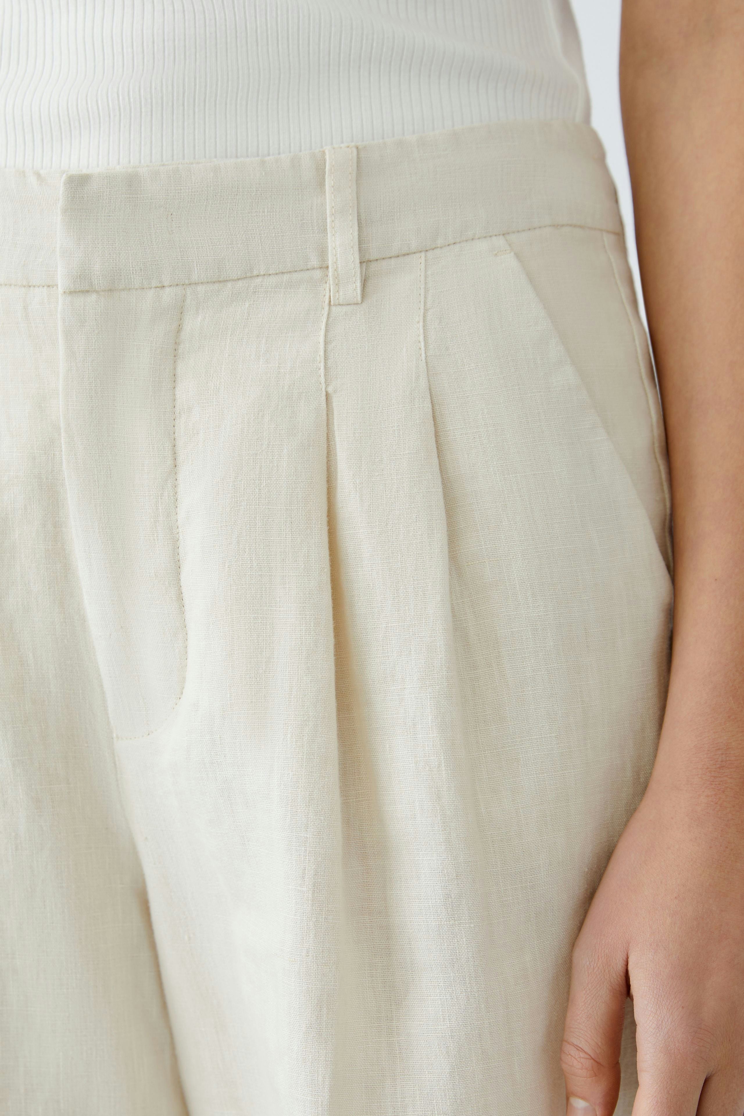 Bequeme Damen-Bermuda: Helle, lockere Hose mit eleganten Falten und seitlichen Taschen.