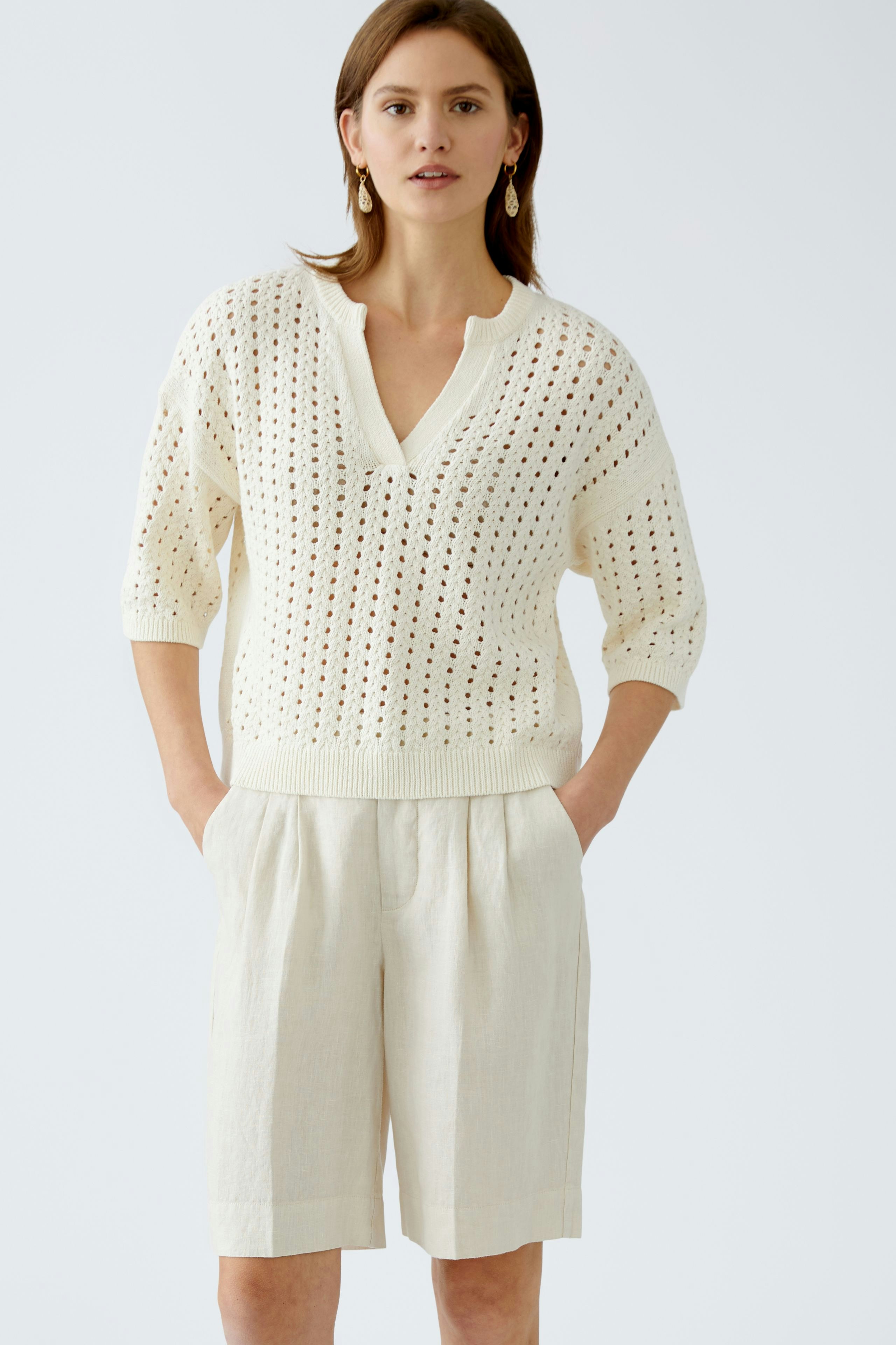 Bequeme Damen-Bermuda: Junge Frau in hellen, lässigen Shorts mit weitem Schnitt und seitlichen Taschen.