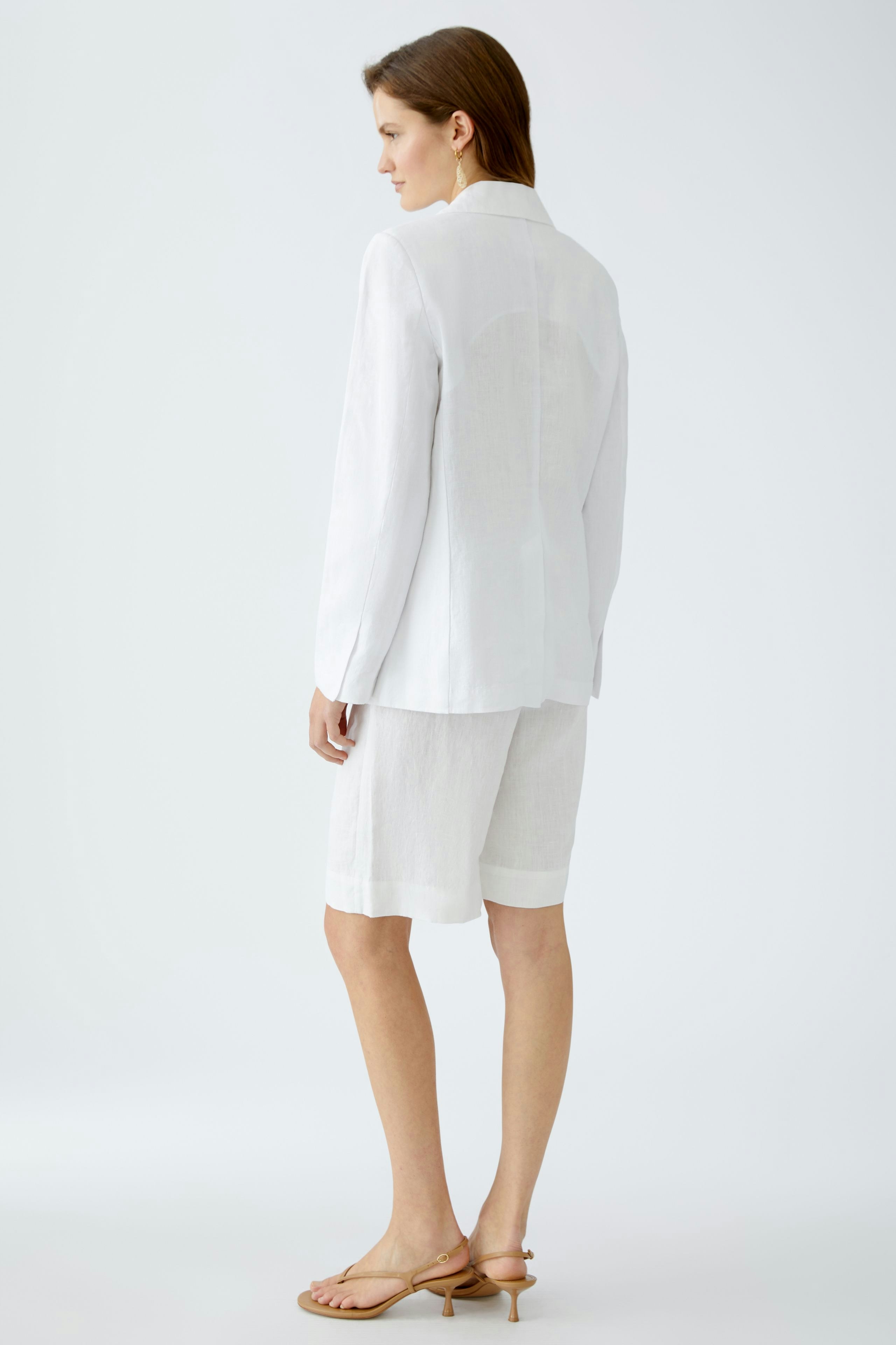 Eleganter Damen-Blazer: Frau in weißem Blazer mit lässigen Shorts, ideal für stilvolle Anlässe.