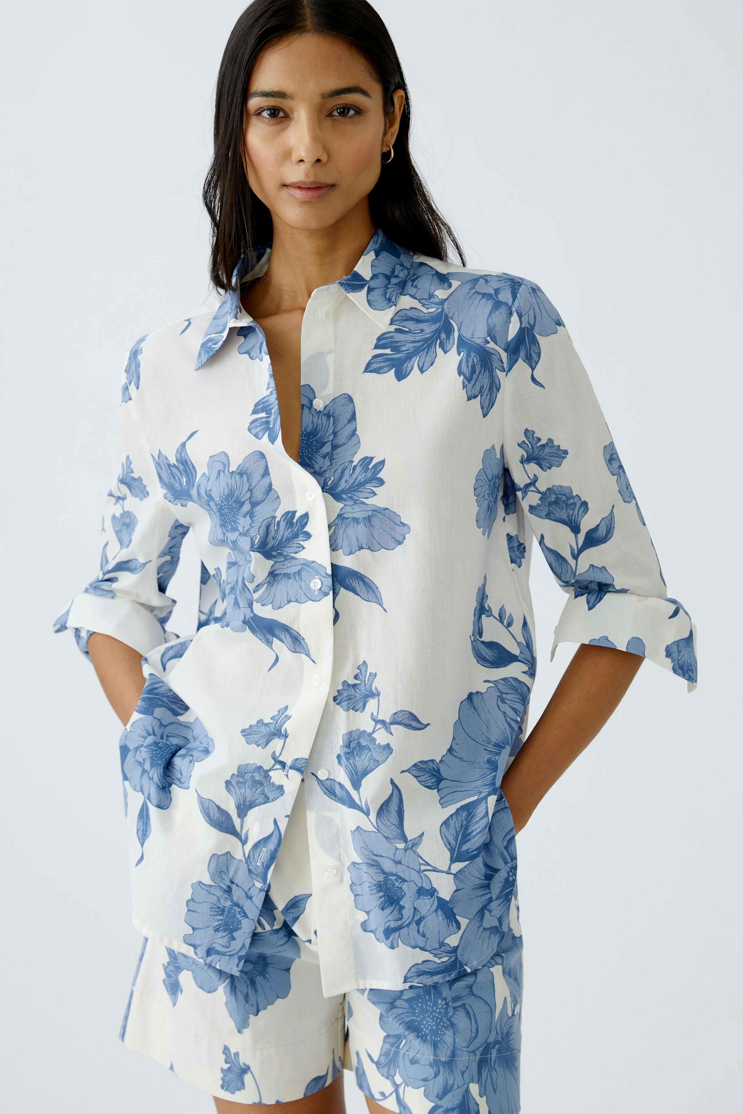 Stylish women's blouse: A woman in a floral-patterned blouse with pockets, exuding elegance.