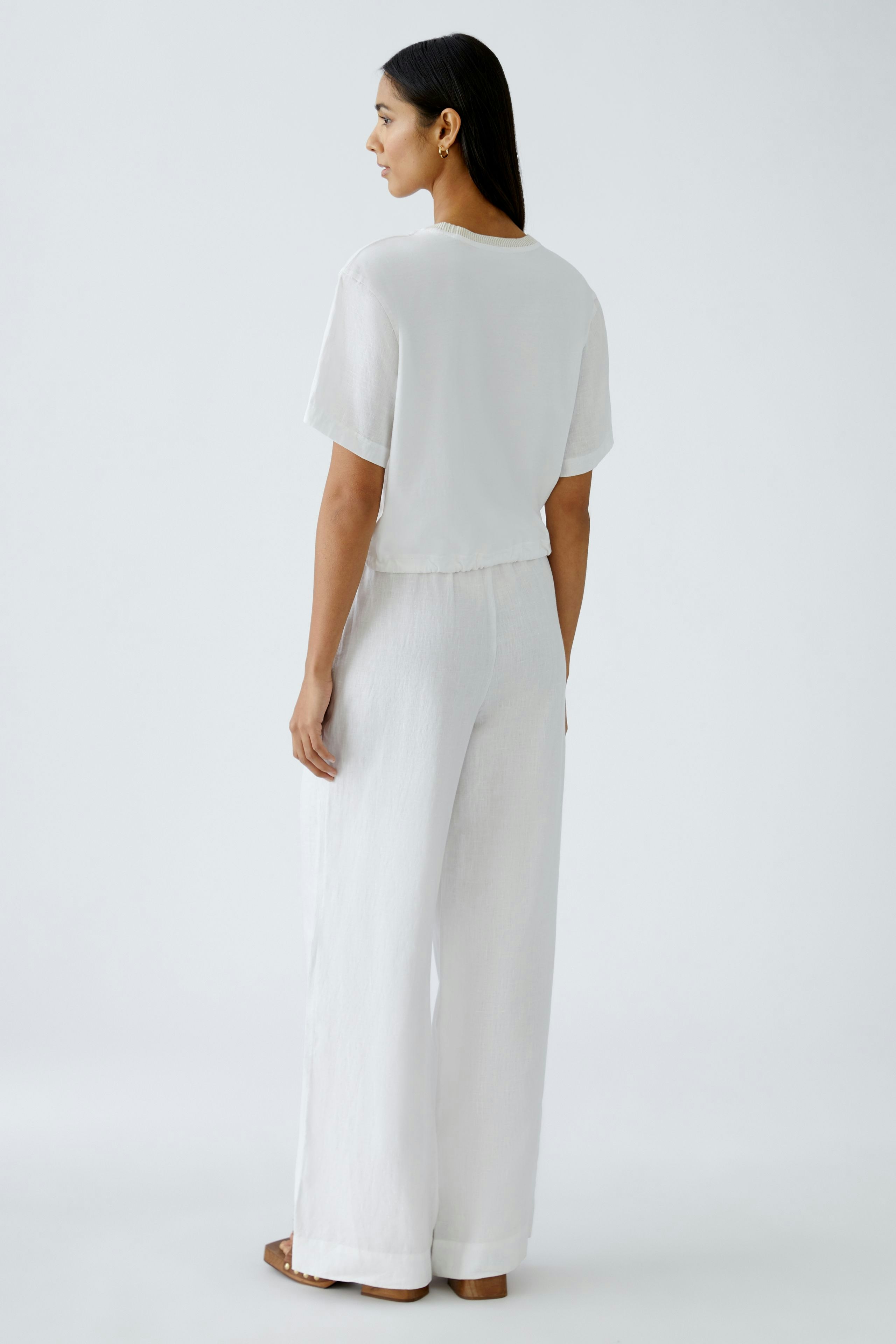 Elegantes Blusenshirt: Frau in weißem, lässigem Shirt mit kurzen Ärmeln und lockerer Passform.