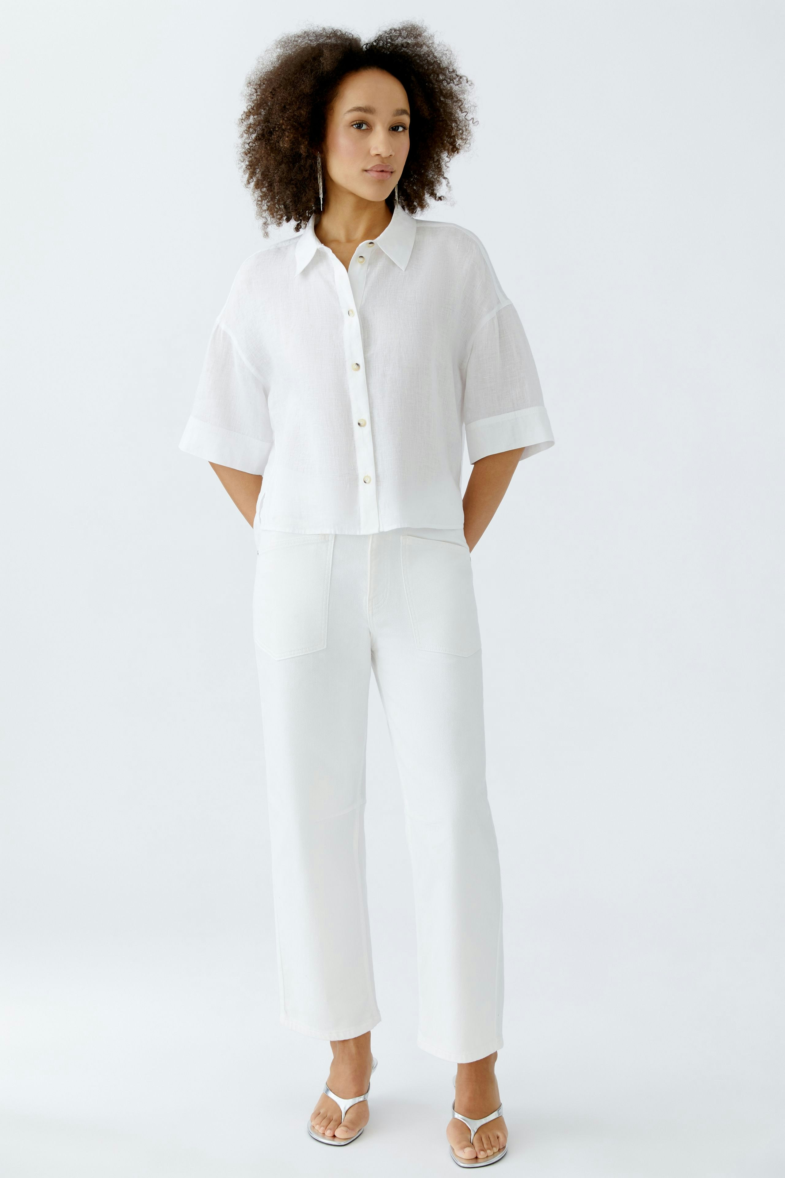 Casual women's blouse: A woman in a white short-sleeve blouse with buttons and relaxed fit.