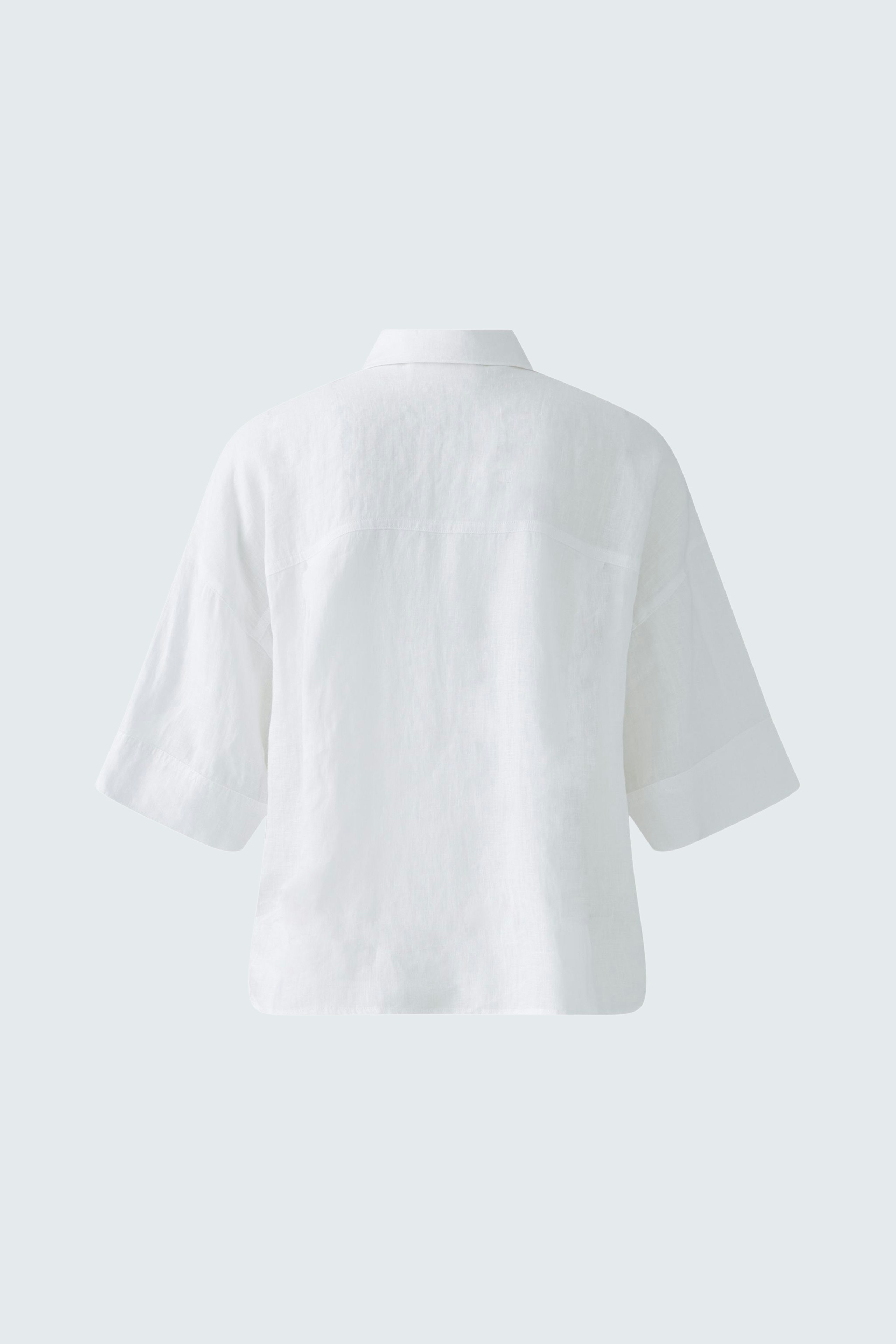 Casual women's blouse: A woman in a white short-sleeve blouse with a relaxed fit.