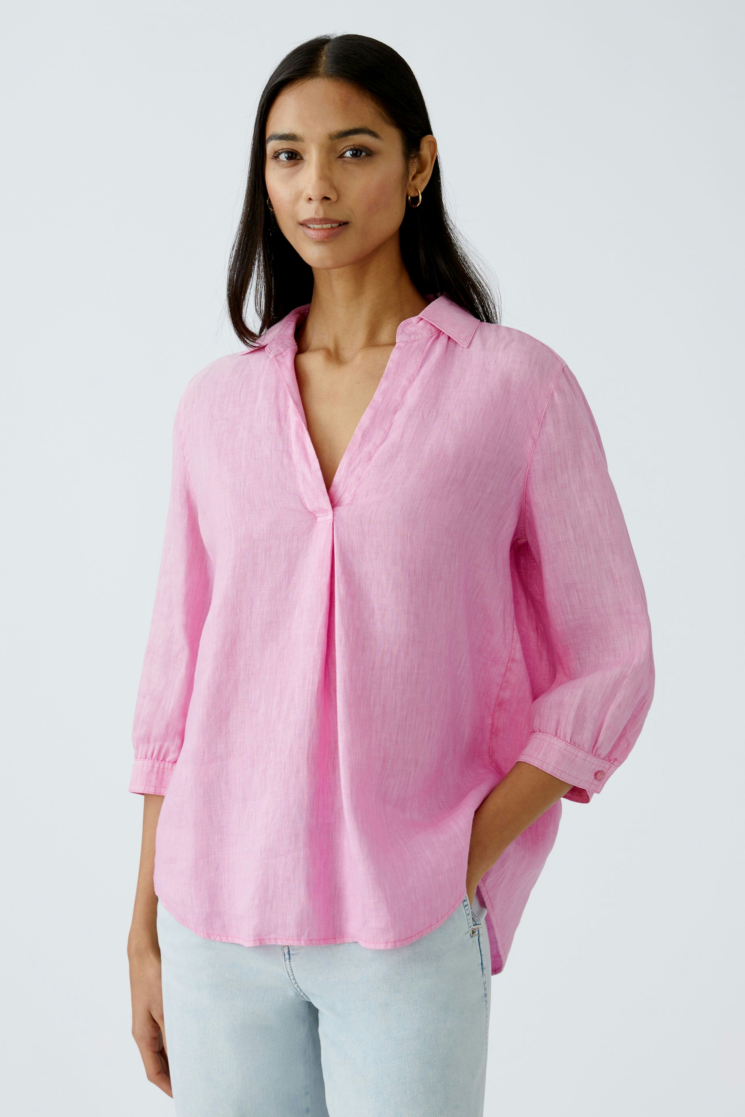 Light pink tunic: Woman in a relaxed fit, long-sleeve tunic with a collar.