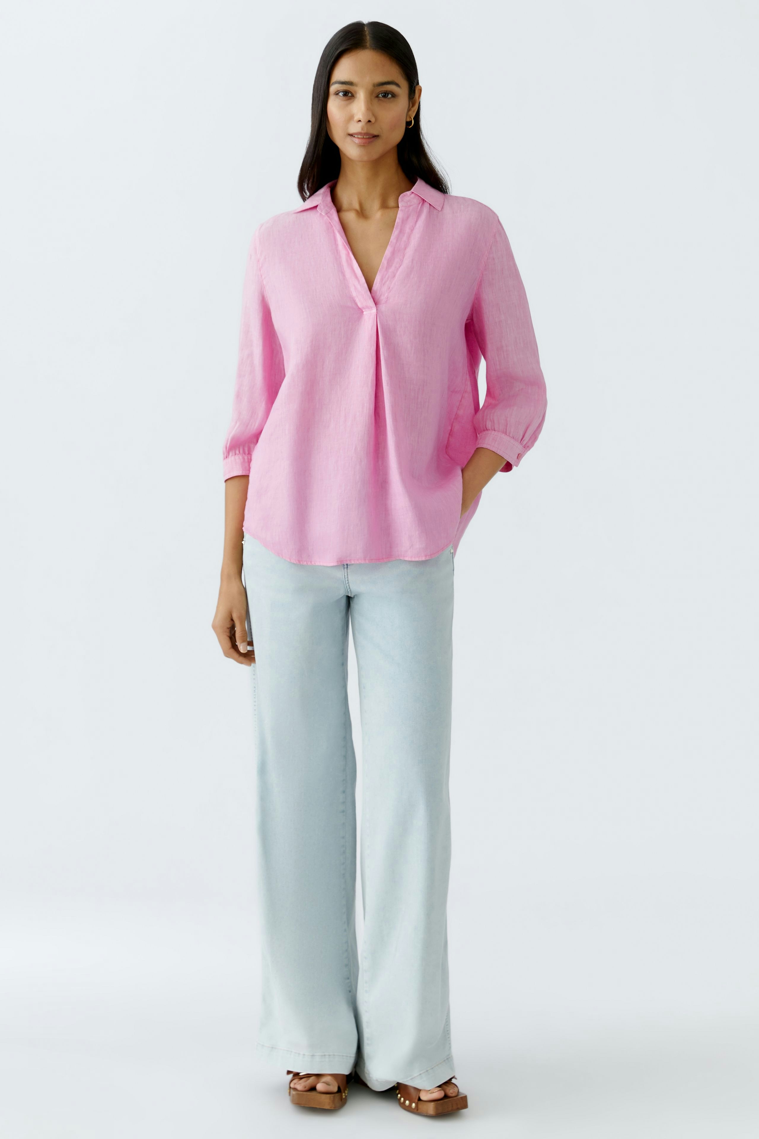 Stylish tunic: A woman in a pink linen tunic with a relaxed fit and three-quarter sleeves.