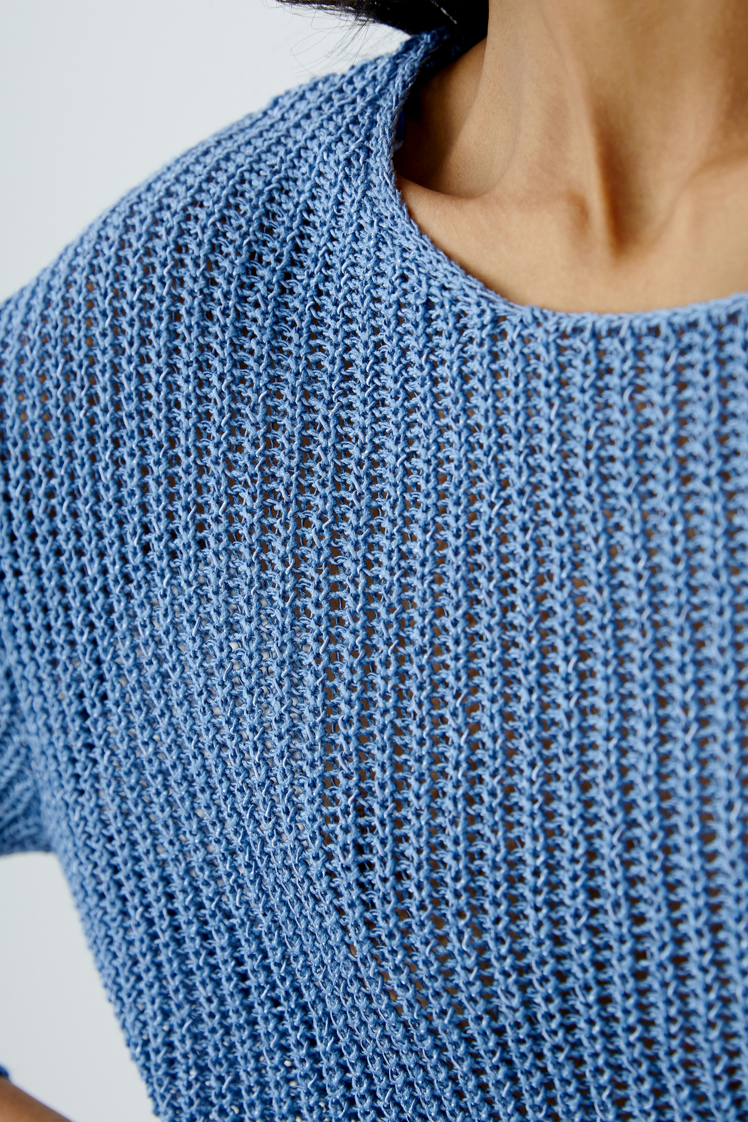 Stylish women's pullover: Close-up of a light blue knitted pullover with a relaxed neckline.