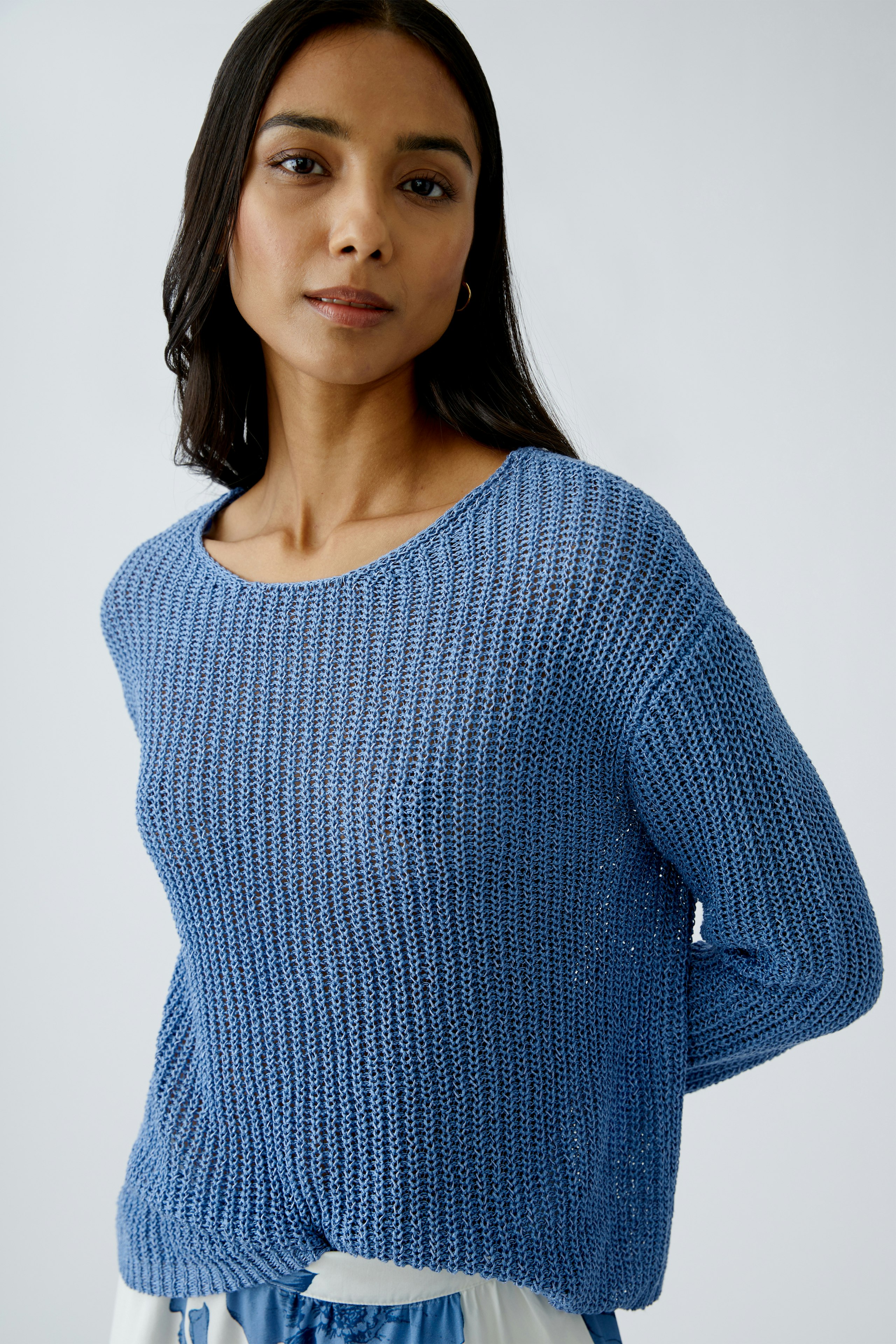 Stylish women's pullover: A woman in a blue knitted pullover, exuding casual elegance.