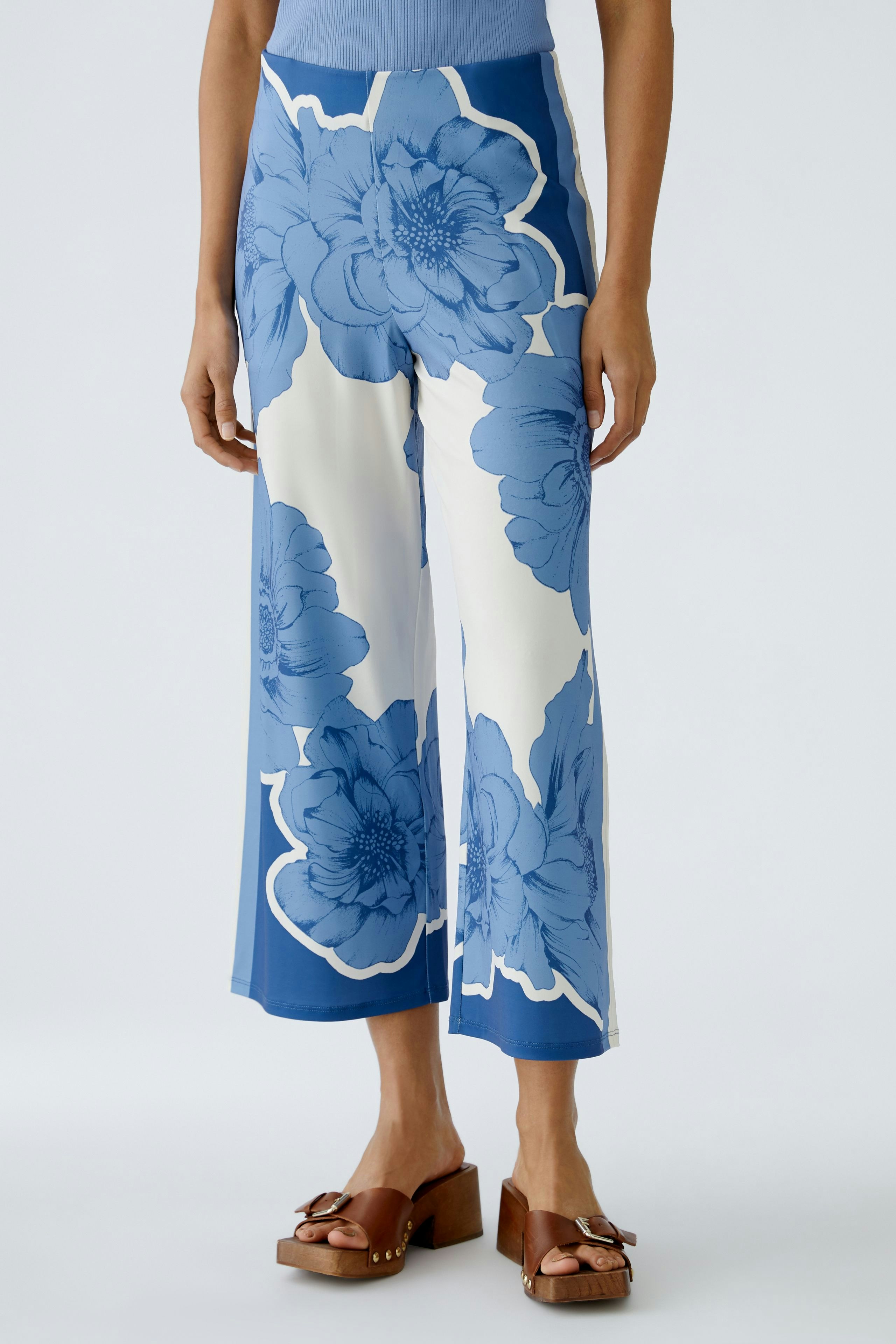 Stylish women's trousers: A woman in blue floral wide-leg pants, paired with brown platform sandals.