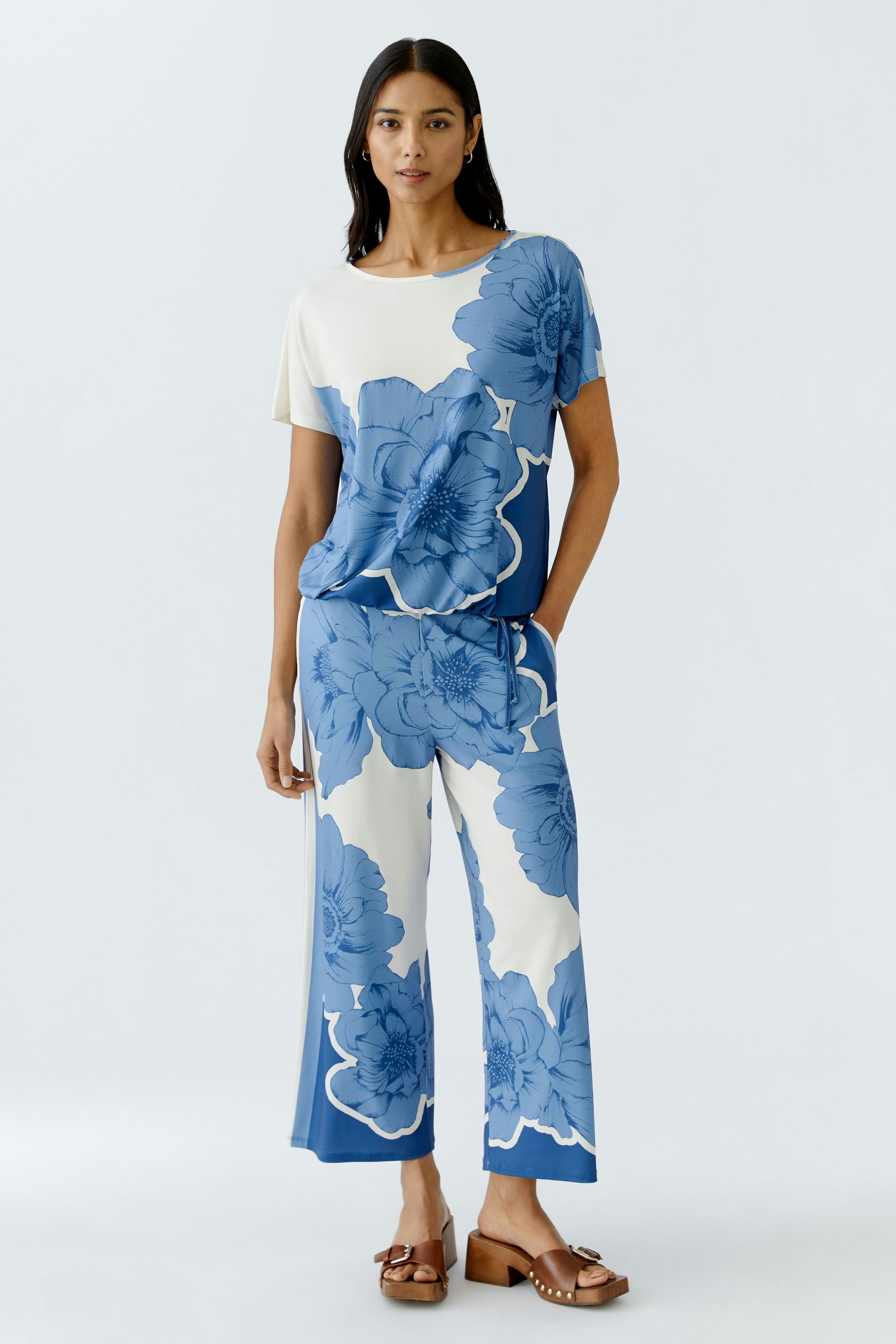 Stylish women's trousers: A woman in blue floral print pants paired with a matching top, exuding elegance.
