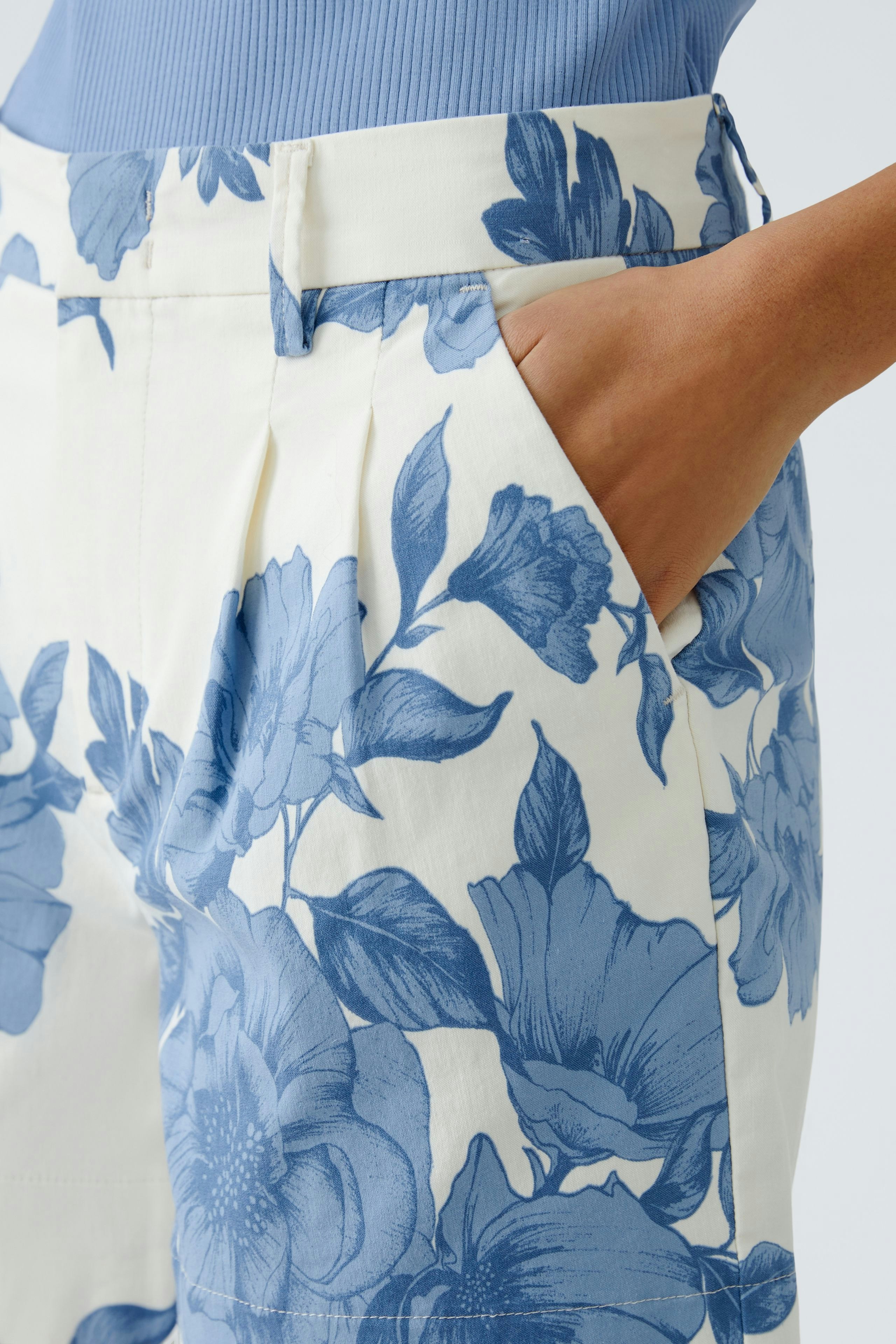 Stylish women's shorts: Close-up of a woman in floral shorts with pockets, perfect for summer.