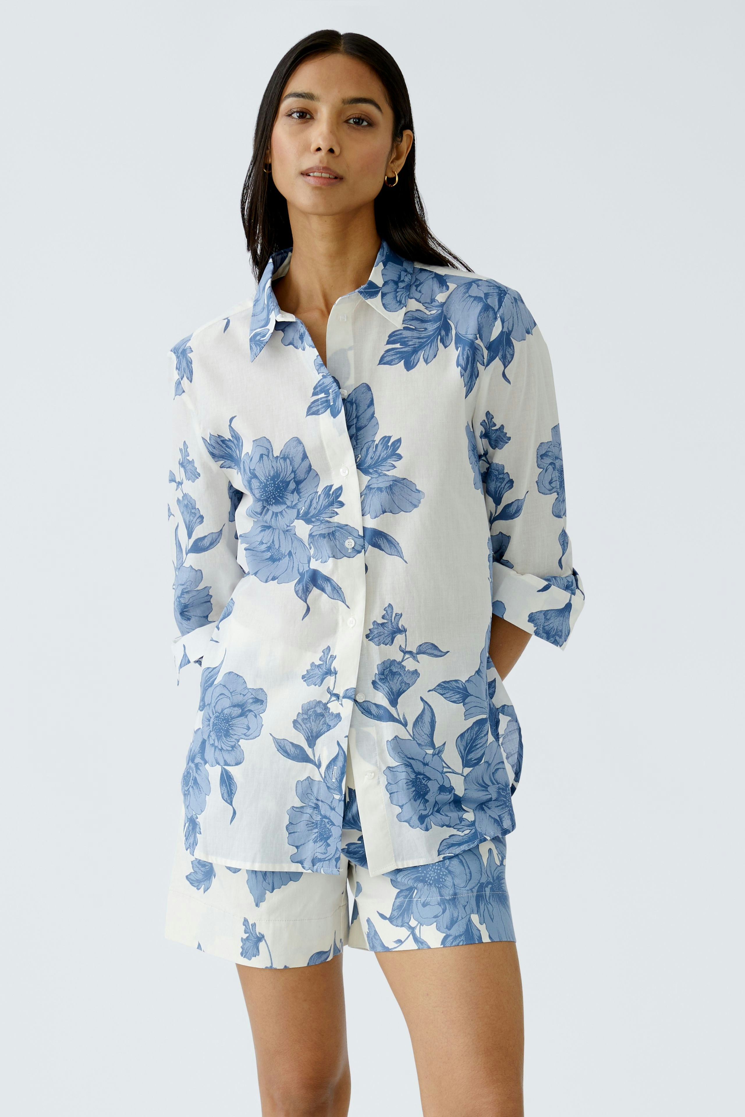 Stylish women's shorts: A woman in floral shorts paired with a matching shirt, exuding summer vibes.