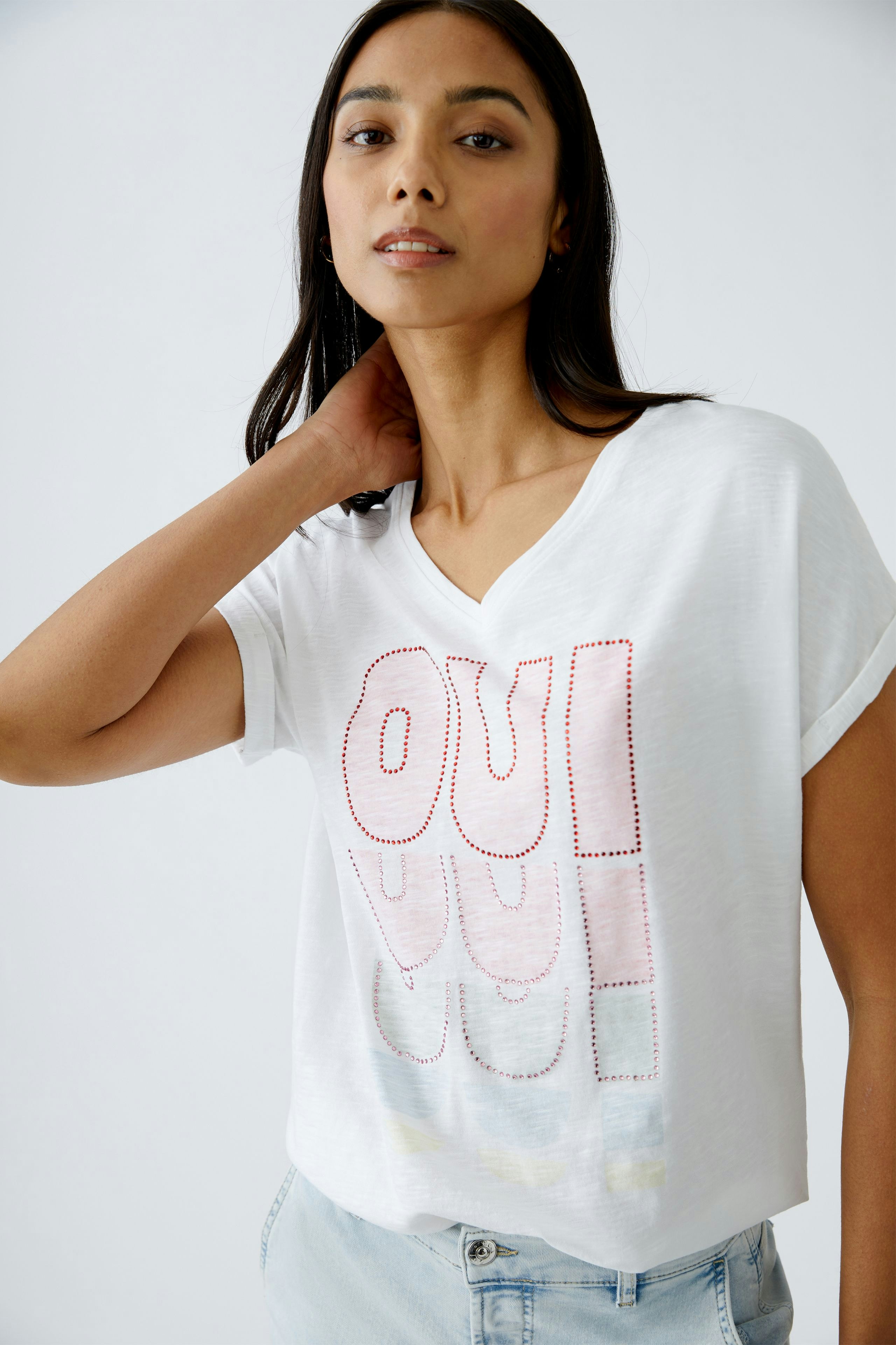 Damen-T-Shirt: Junge Frau in weißem T-Shirt mit rotem Schriftzug, lässig und modern.