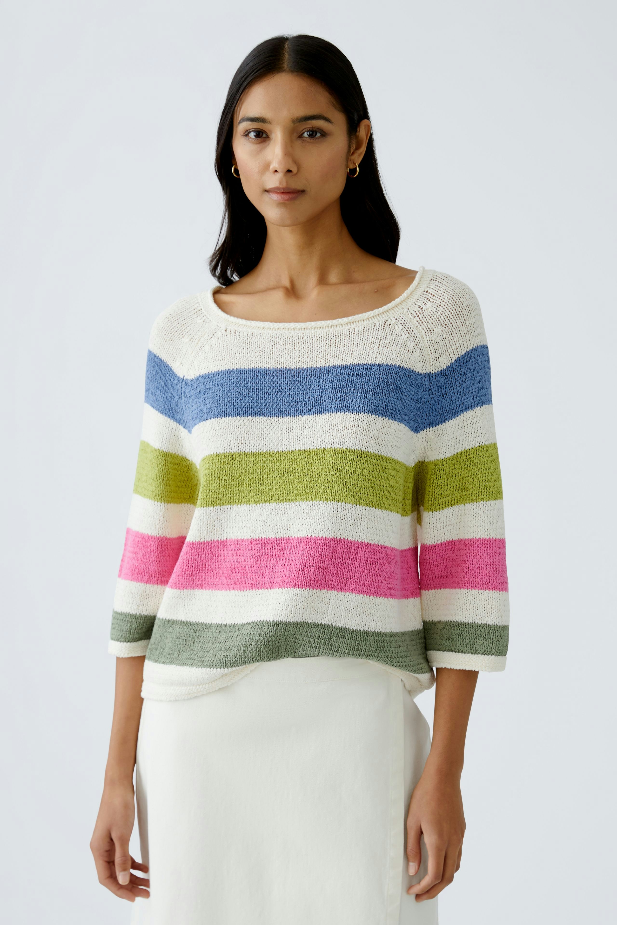 Stylish women's pullover: A woman in a colorful striped pullover, paired with a light skirt.
