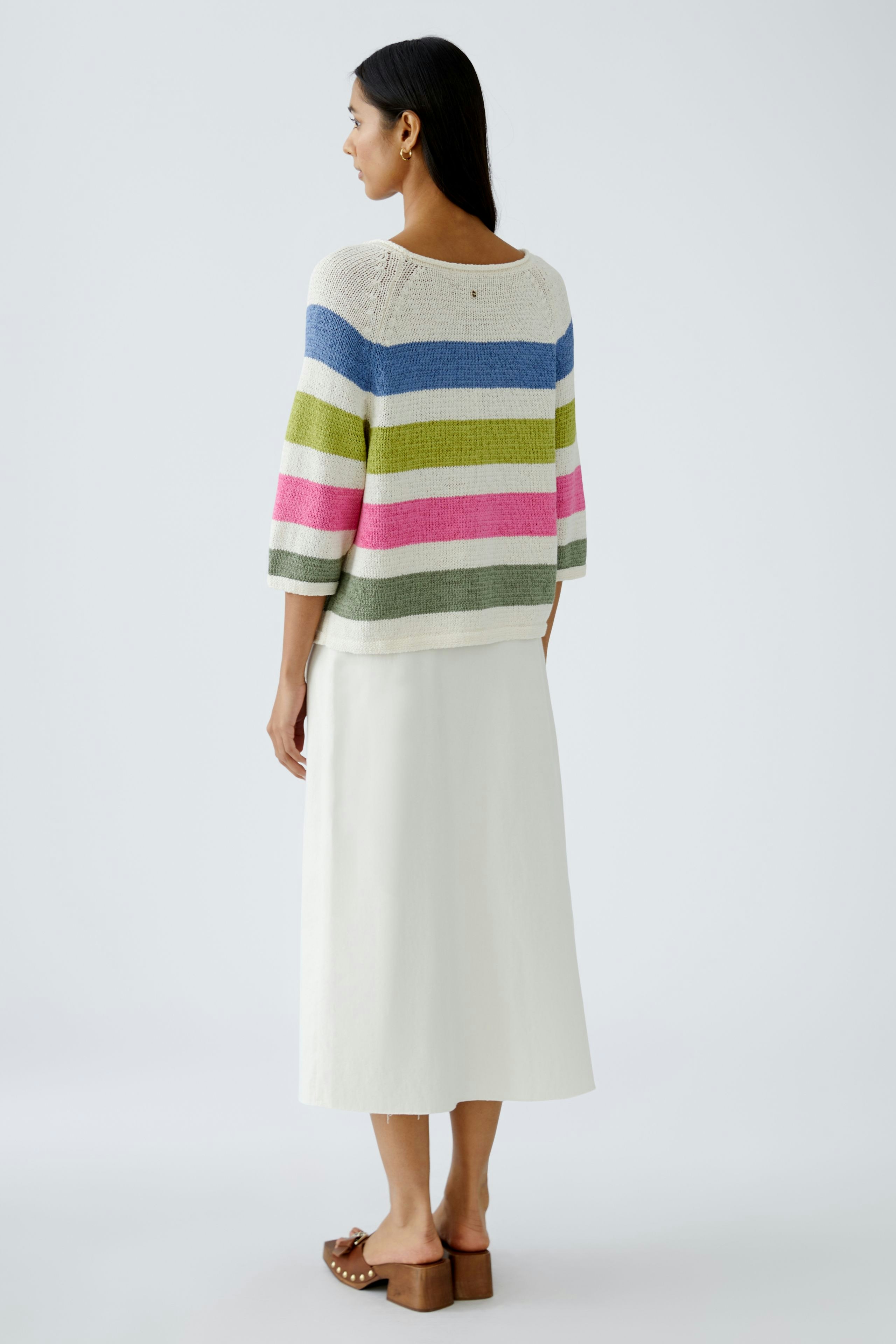 Stylish women's pullover: A woman in a colorful striped pullover with three-quarter sleeves.