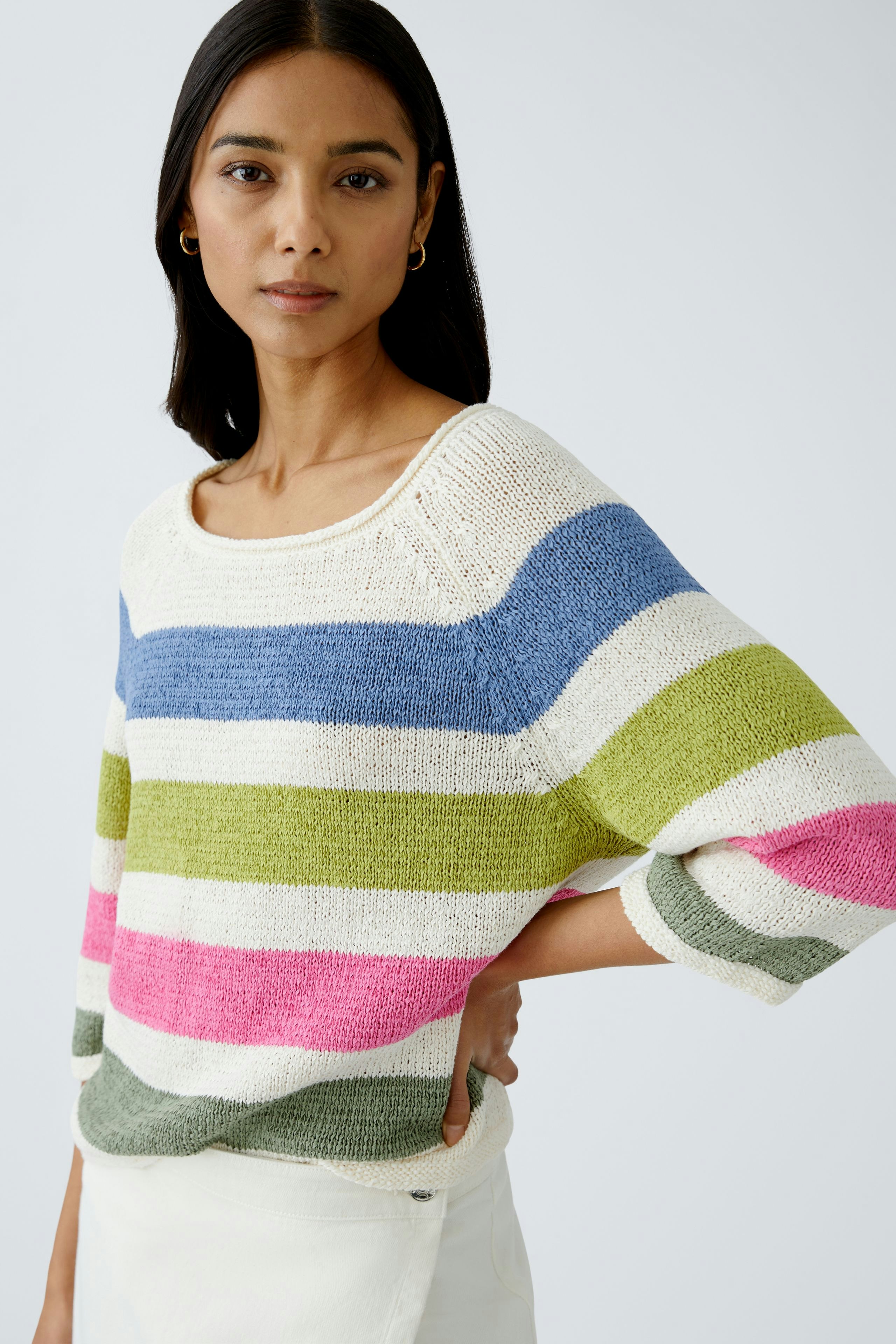 Stylish women's pullover: A woman in a colorful striped pullover, exuding casual elegance.