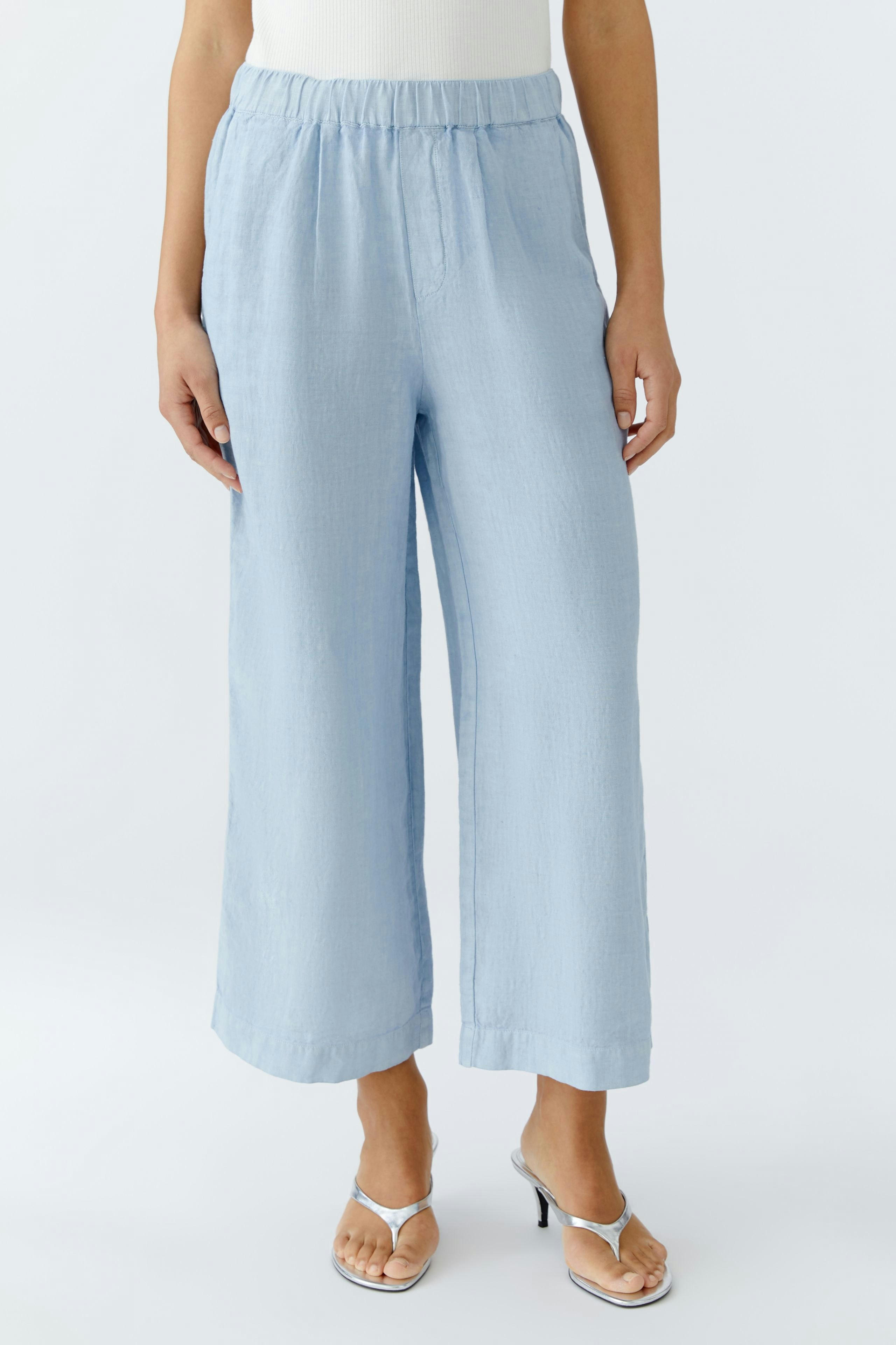 Light blue culottes: Woman in relaxed-fit, wide-leg pants with an elastic waistband.