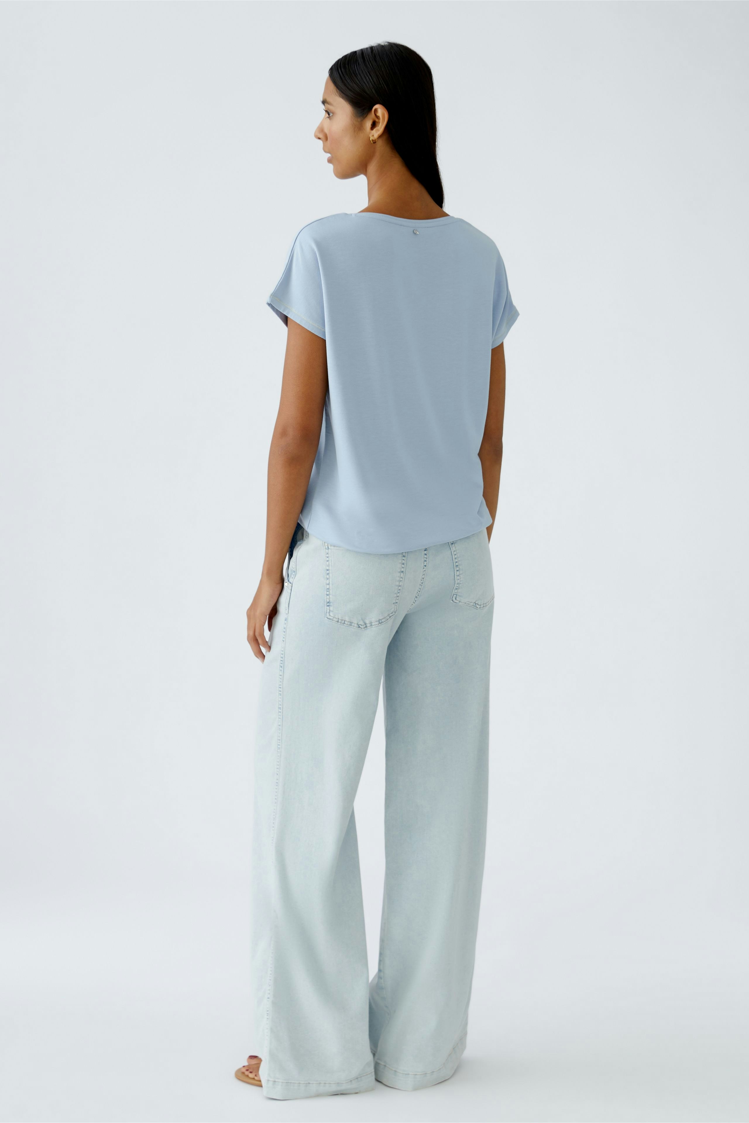 Casual women's T-shirt: A woman in a light blue T-shirt with short sleeves and relaxed fit.