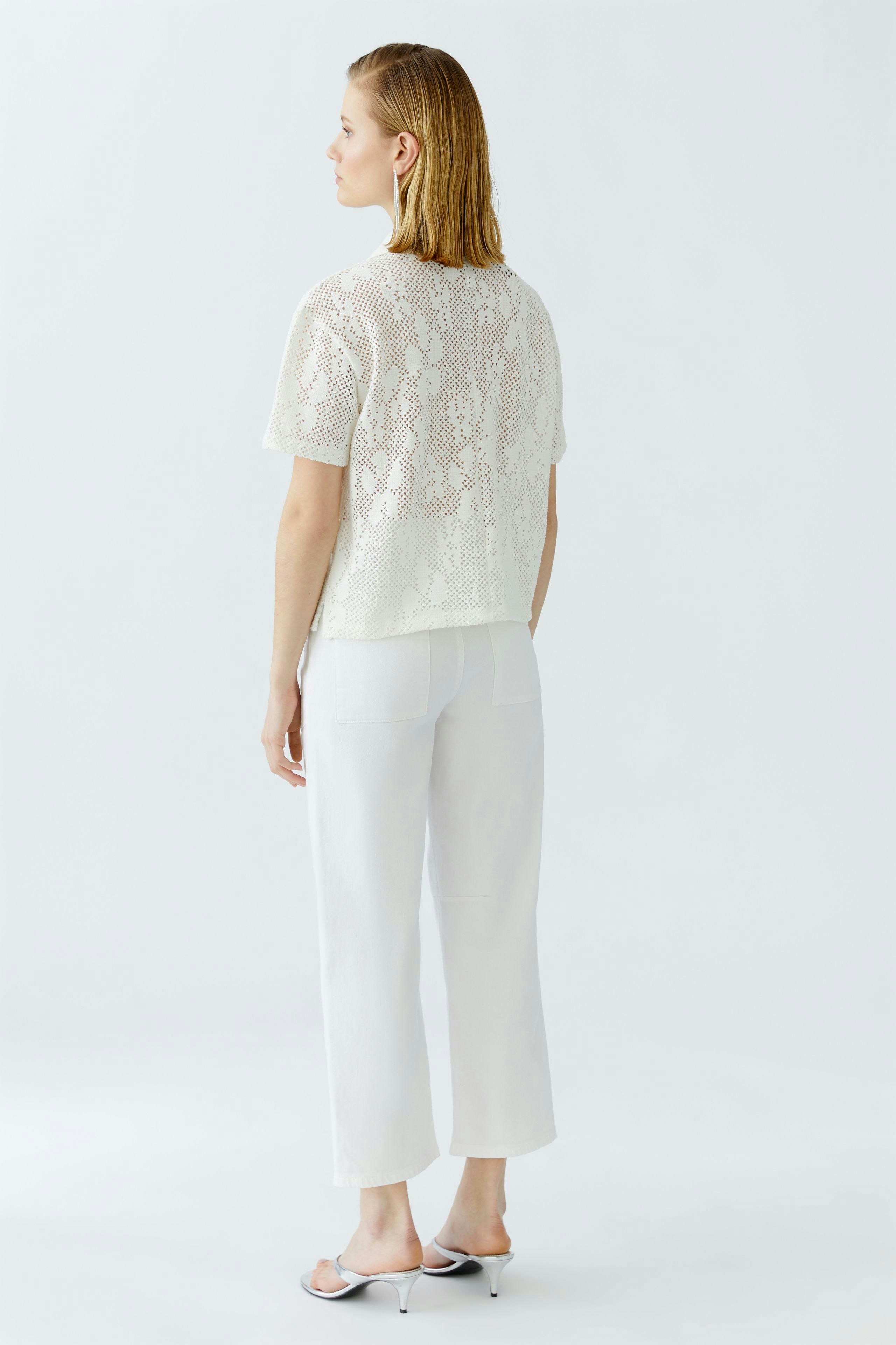 Damen-Poloshirt: Frau mit kurzem, weißem Poloshirt aus leichtem Material, lässig und modern.