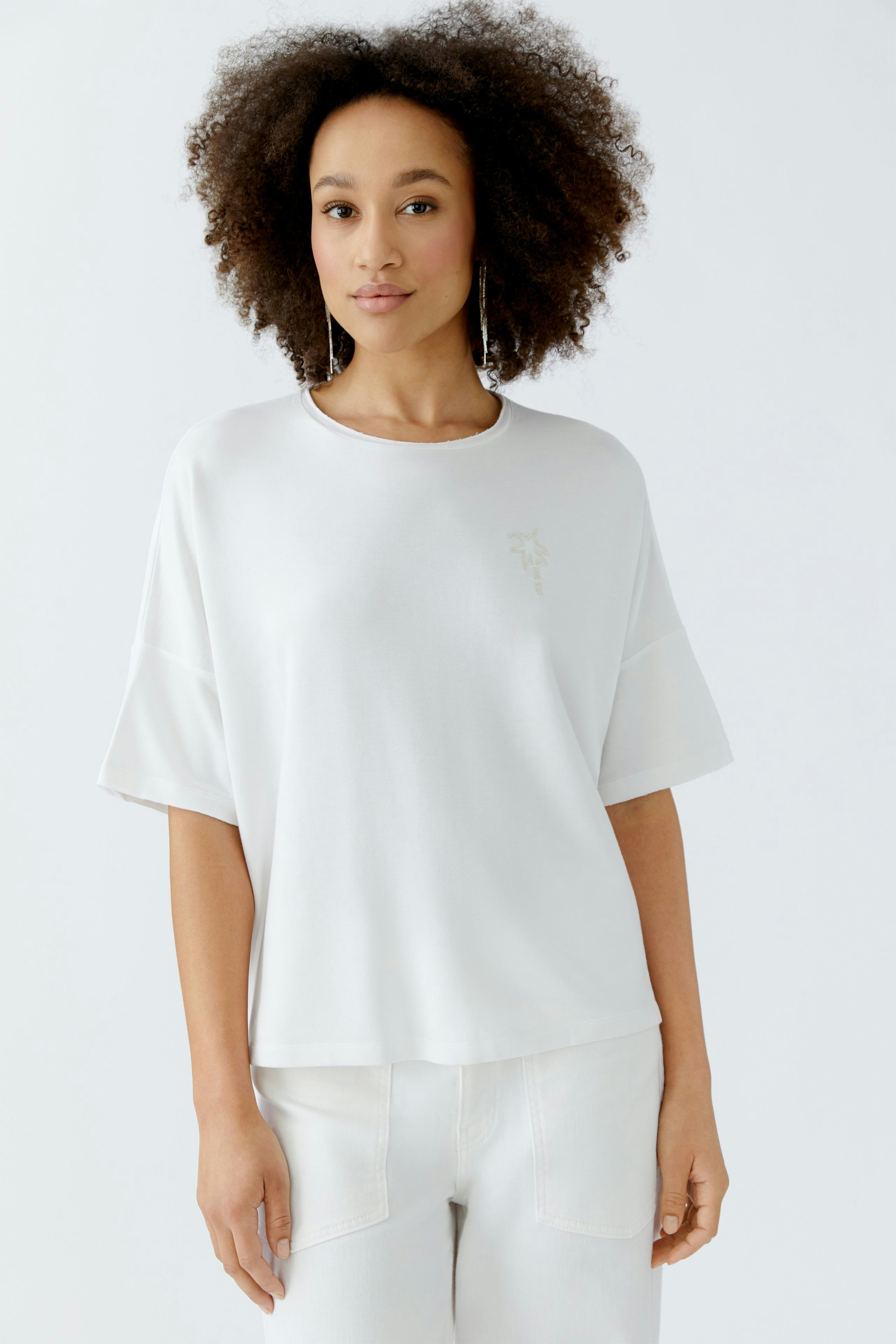 Bequemer Damen-Sweatshirt: Frau in weißem, lässigem Pullover mit kurzen Ärmeln und dezentem Logo.