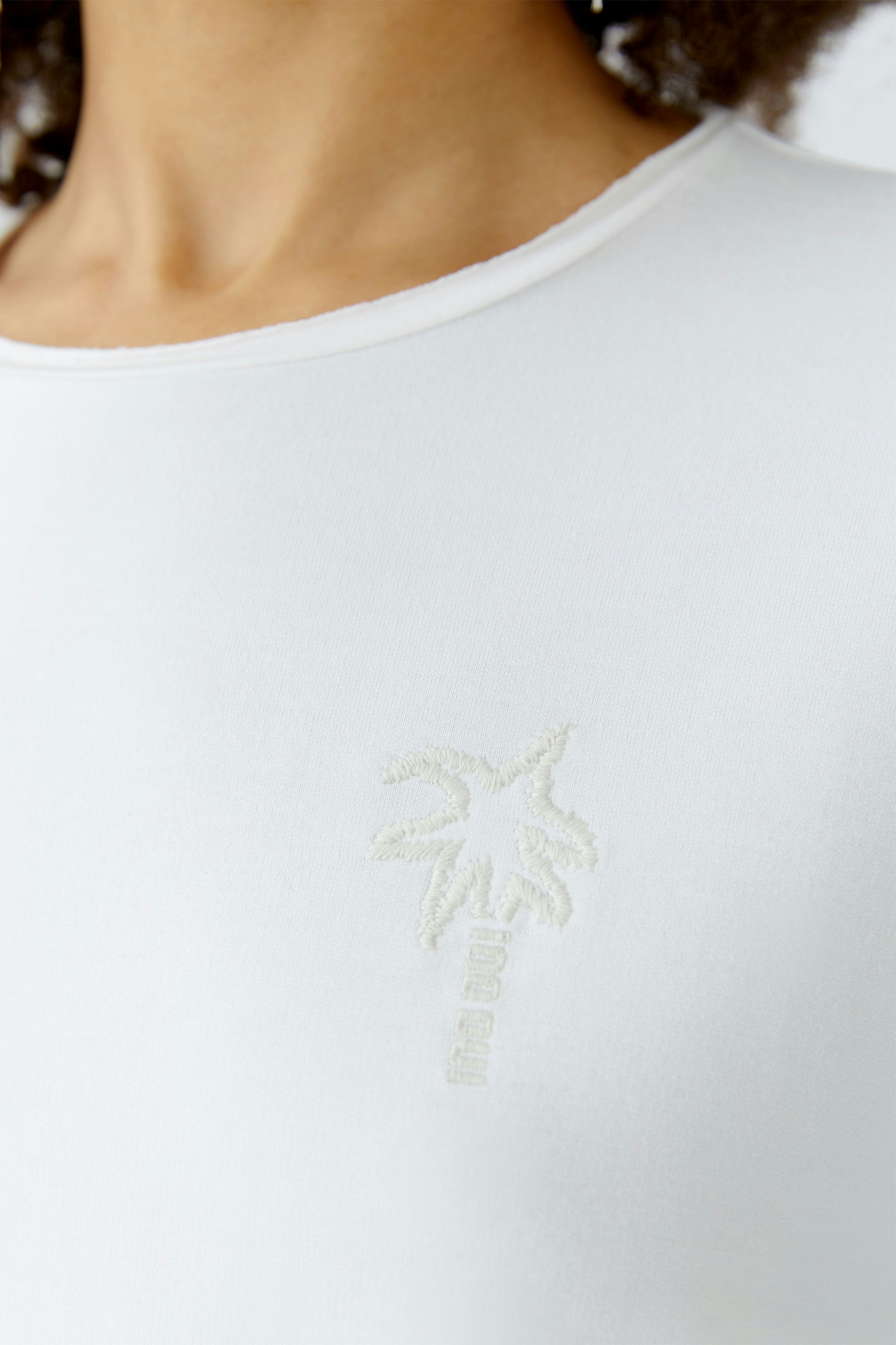 Bequemer Damen-Sweatshirt: Frau trägt ein weißes Sweatshirt mit dezentem Palmendruck.