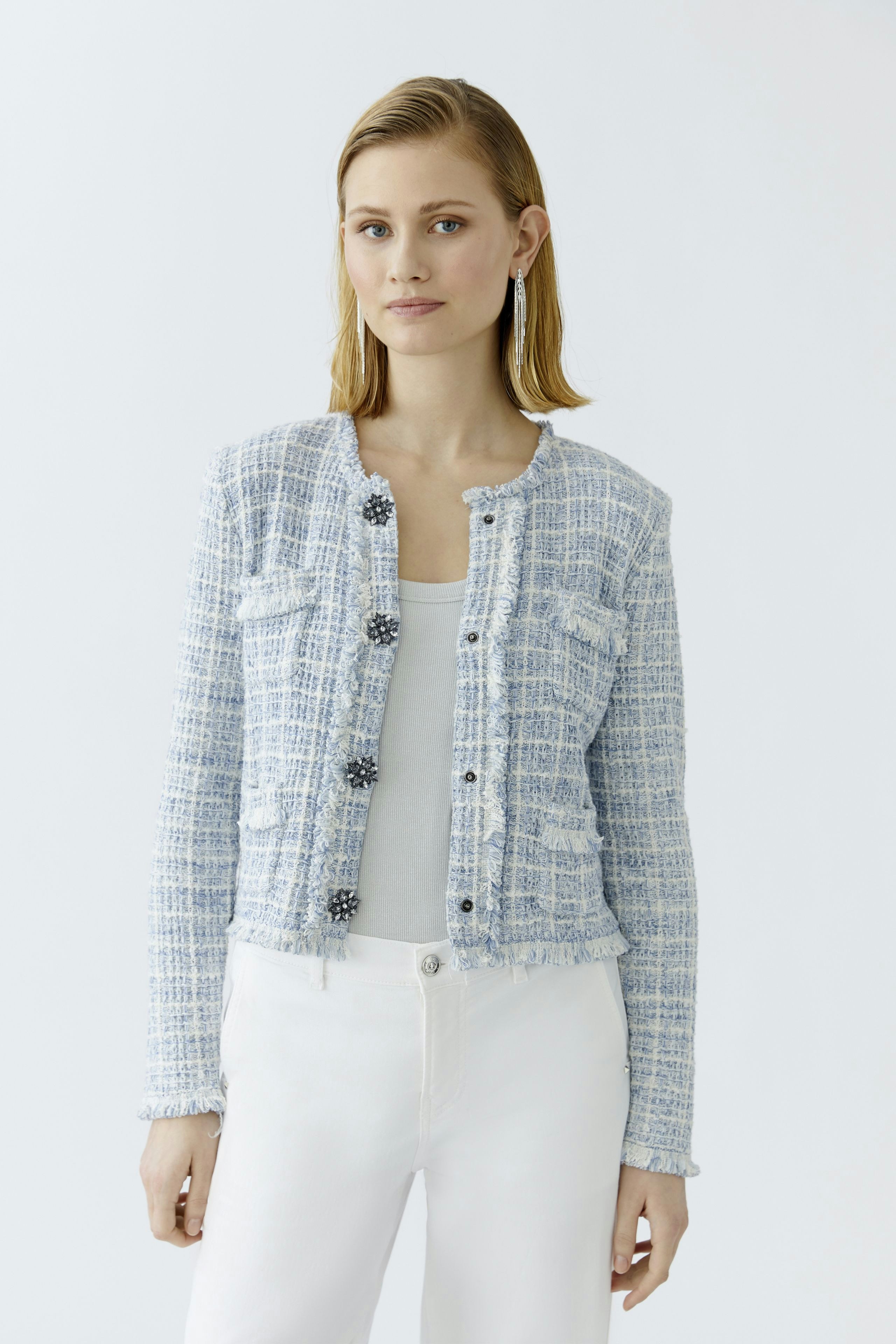 Casual women's cardigan: A woman in a light blue cardigan with pockets and buttons, paired with white pants.