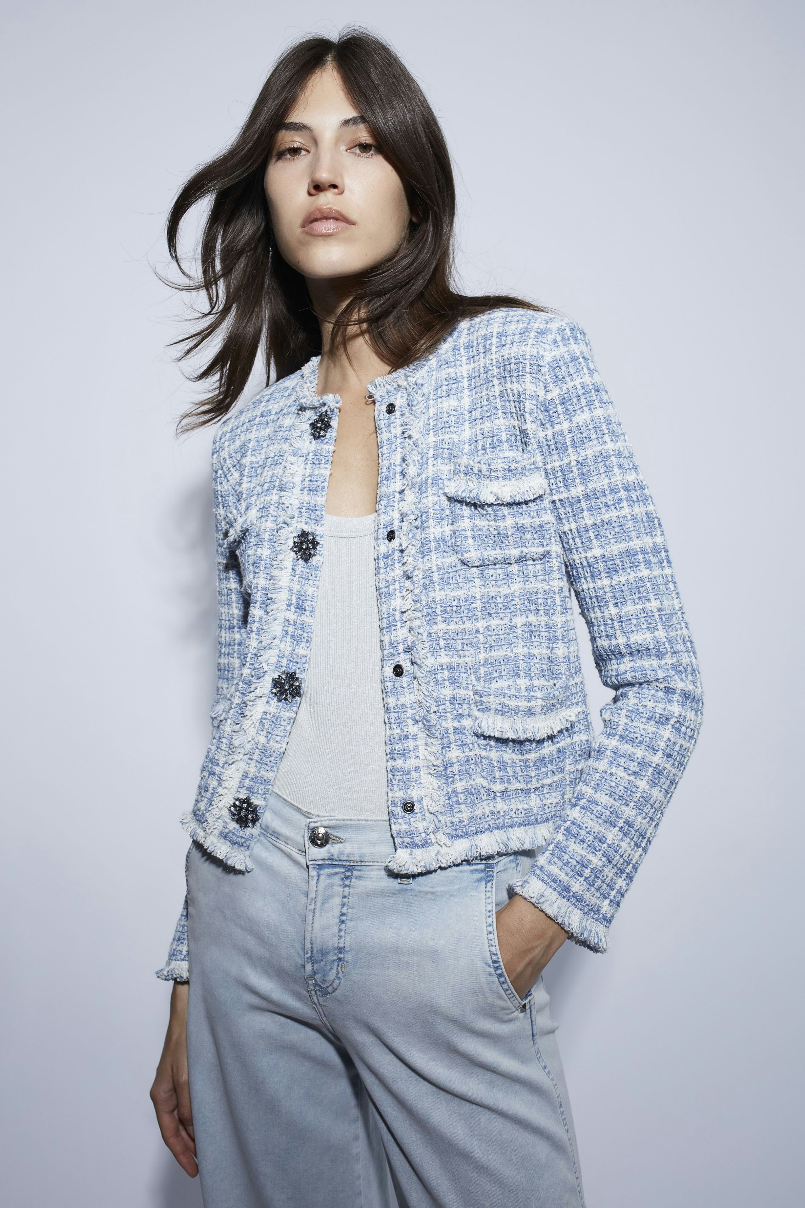 Casual women's cardigan: A woman in a blue textured cardigan with pockets and a simple top.