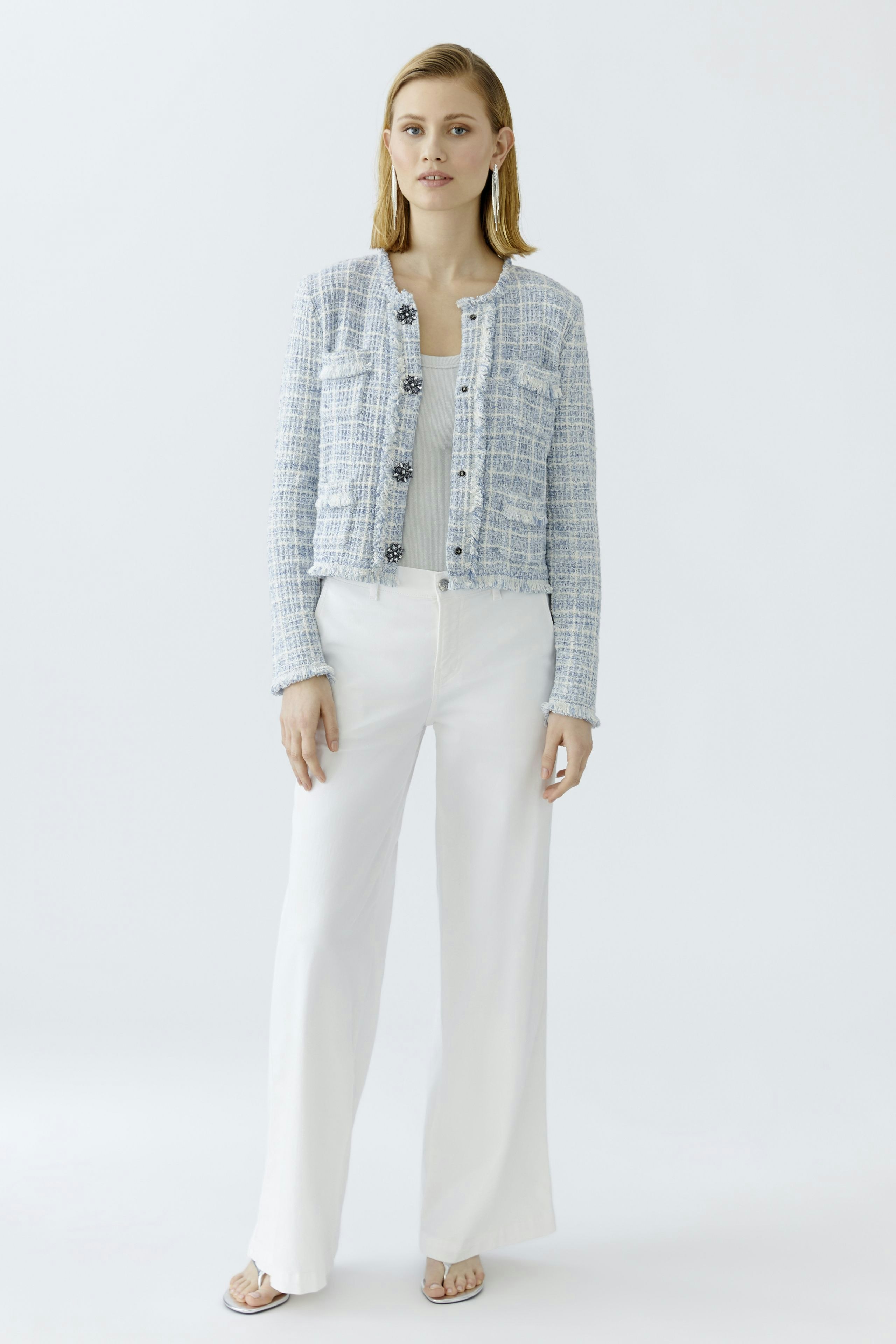 Casual women's cardigan: A woman in a light blue textured cardigan with buttons, paired with white pants.