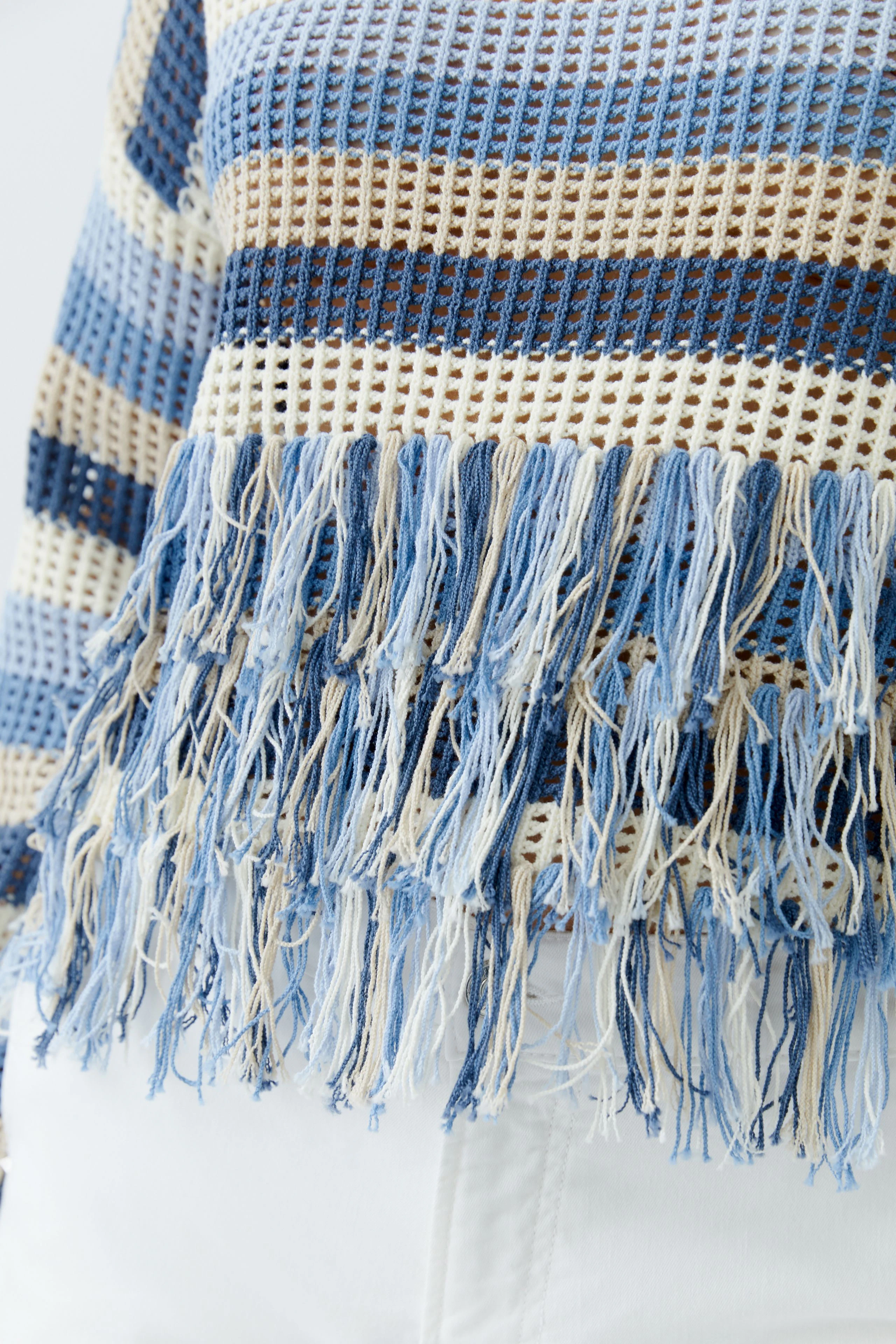 Casual women's pullover: Close-up of a blue striped pullover with fringes, perfect for relaxed outfits.