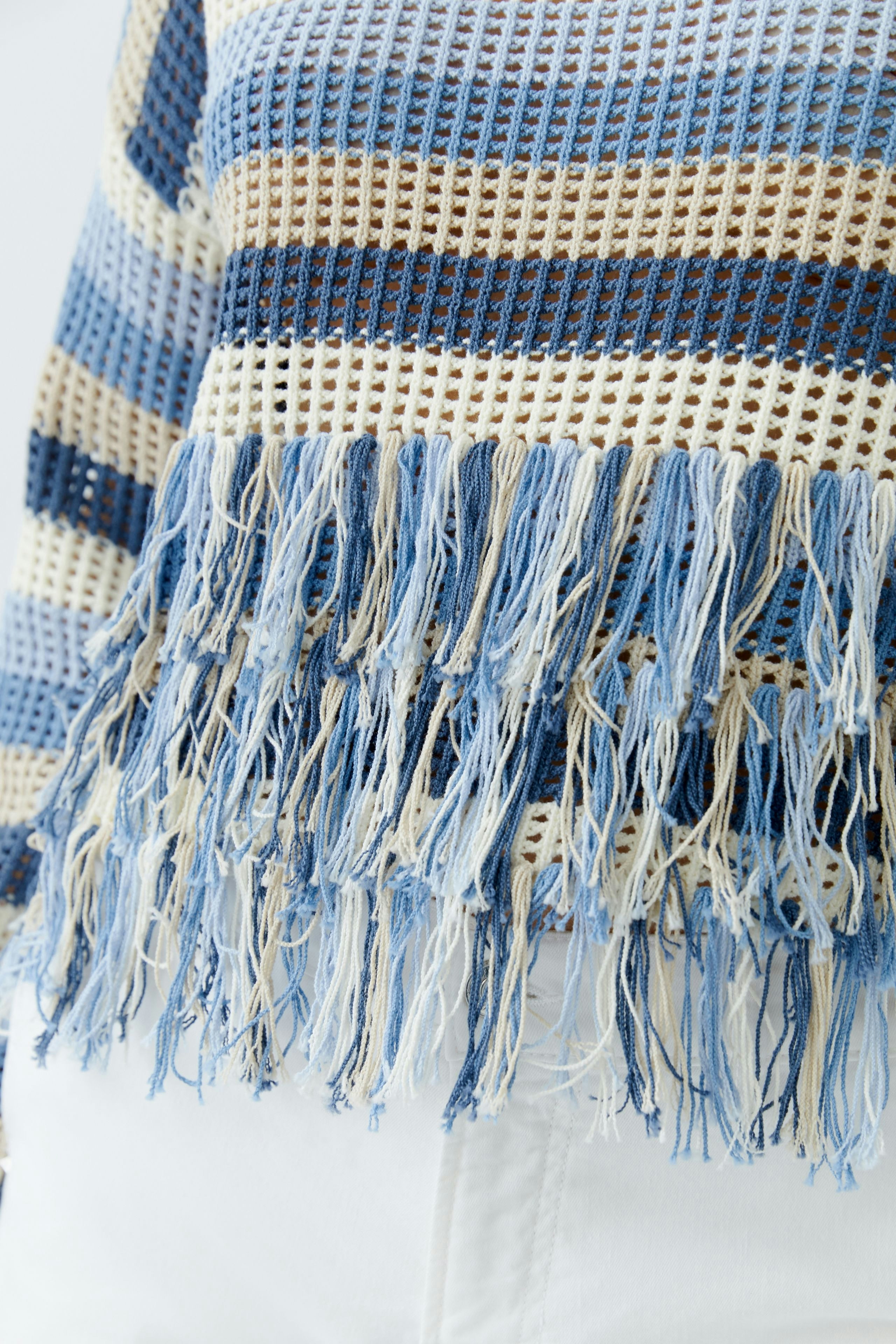 Casual women's pullover: Close-up of a blue striped pullover with fringes, perfect for relaxed outfits.