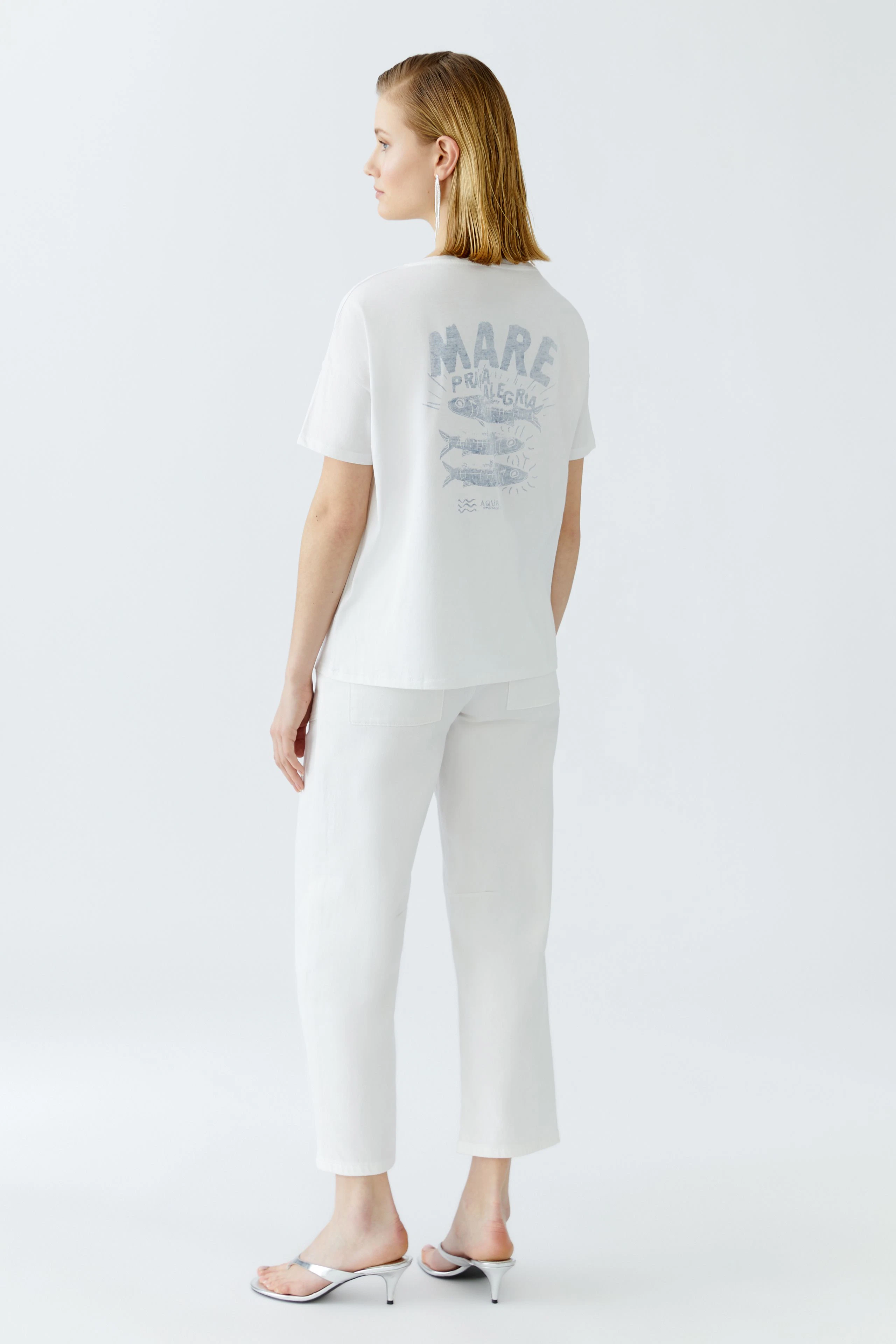 Damen-T-Shirt: Junge Frau trägt ein weißes T-Shirt mit grafischem Druck auf der Rückseite.